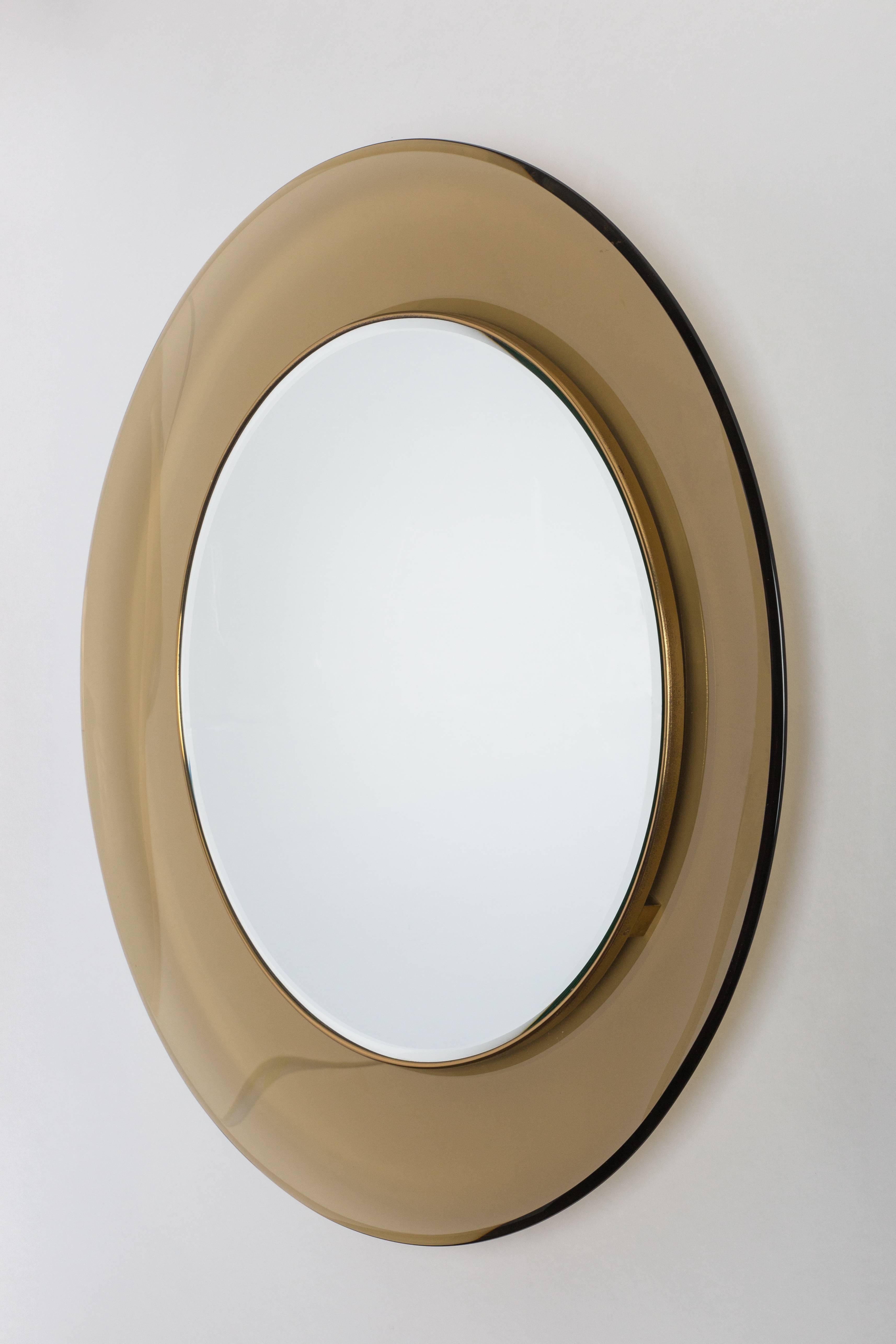 Max Ingrand for Fontana Arte classic and elegant matched pair of amber colored, curved and beveled glass framing mirrored glass encased in brass trim.  
Original Fontana Arte mirrors each dated on the back '1963' and '1965.'

Sold individually or as