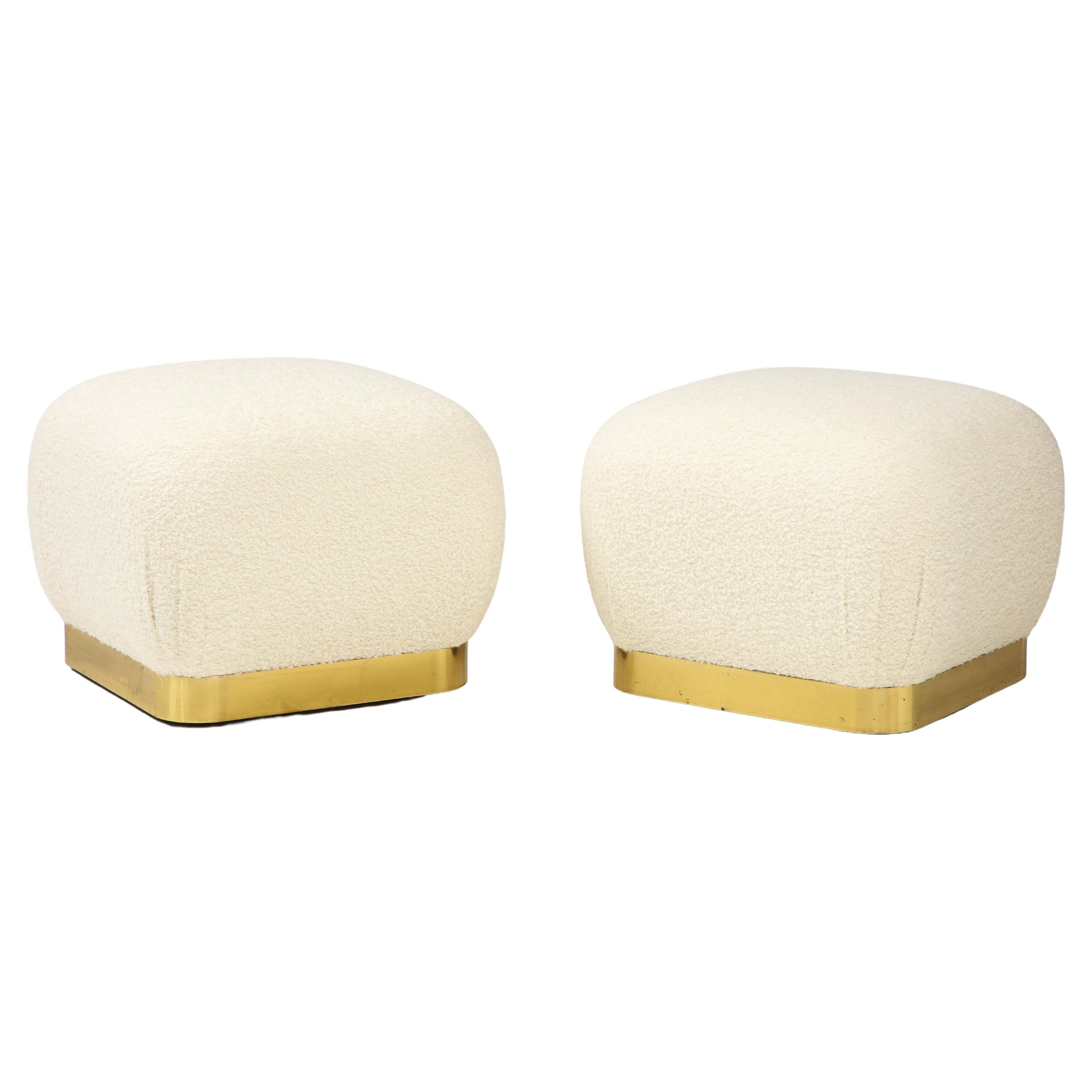 Karl Springer pair of soufflé ottomans with thick rounded ivory bouclé cushions on rounded square lacquered brass bases with caster wheels.
The brass bases are in very good original condition with a beautiful lacquer finish and some patina to the
