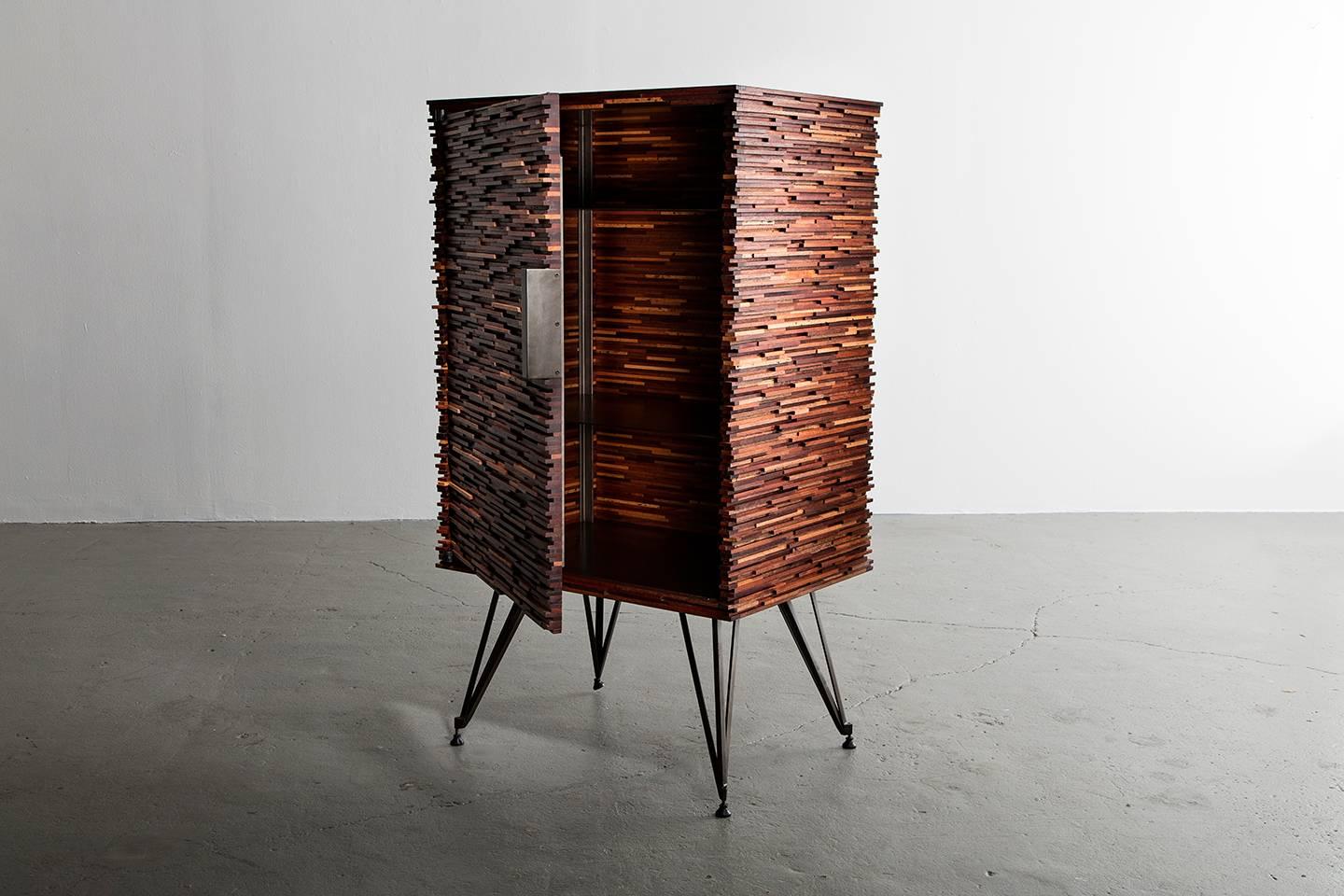 Part of Richard Haining's Stacked Collection, the carcass of this cabinet or dry bar was made using reclaimed mahogany, sapelle, and other tropical hardwoods with similar grain patterns. The base, shelving, and hardware are all made of steel. The