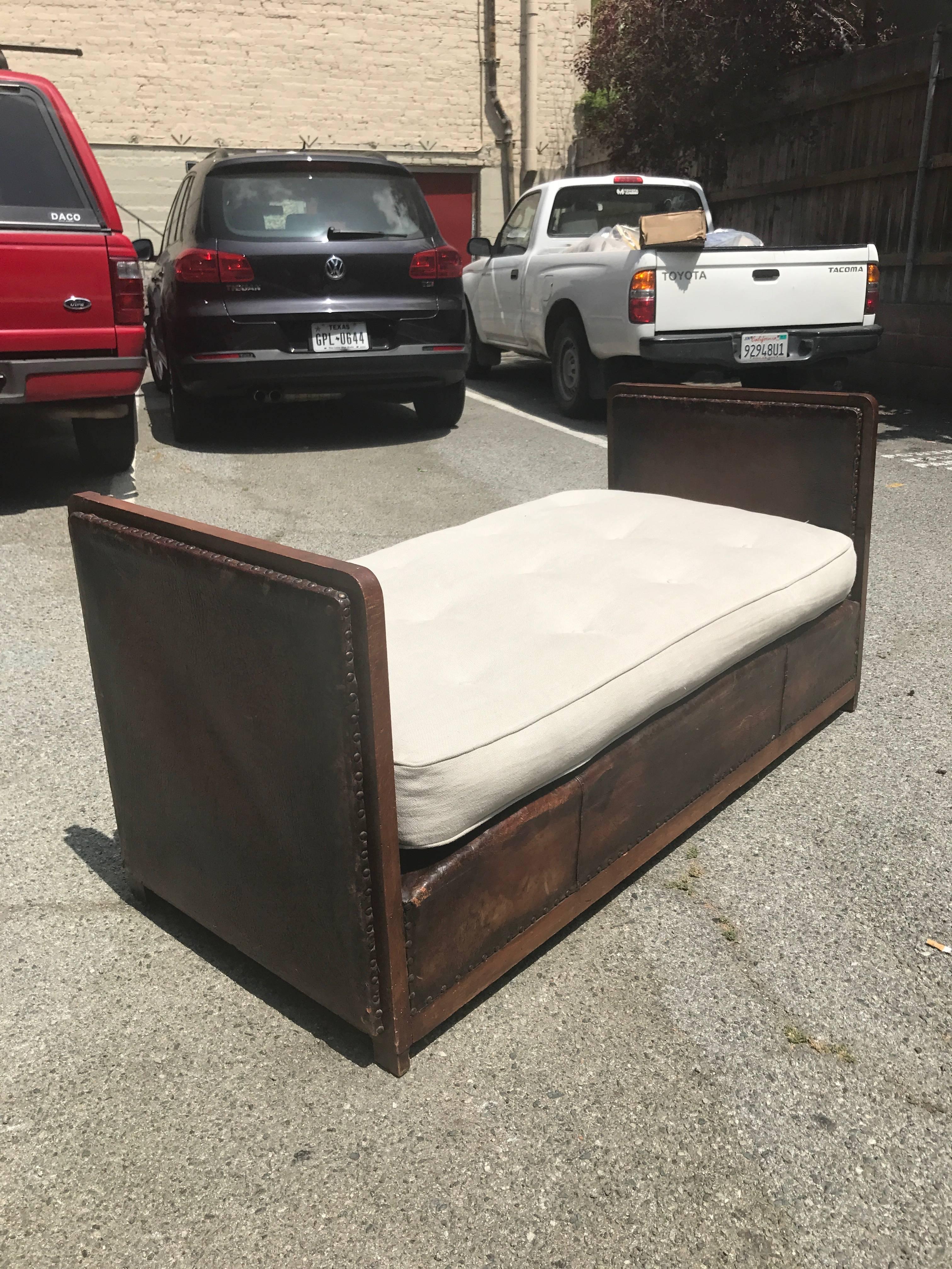 Vintage 1940s bench or daybed with a wooden frame, leather upholstery and nailhead trim. New cushion. This beautiful piece would be perfect for a bedroom, living room, or a boutique!