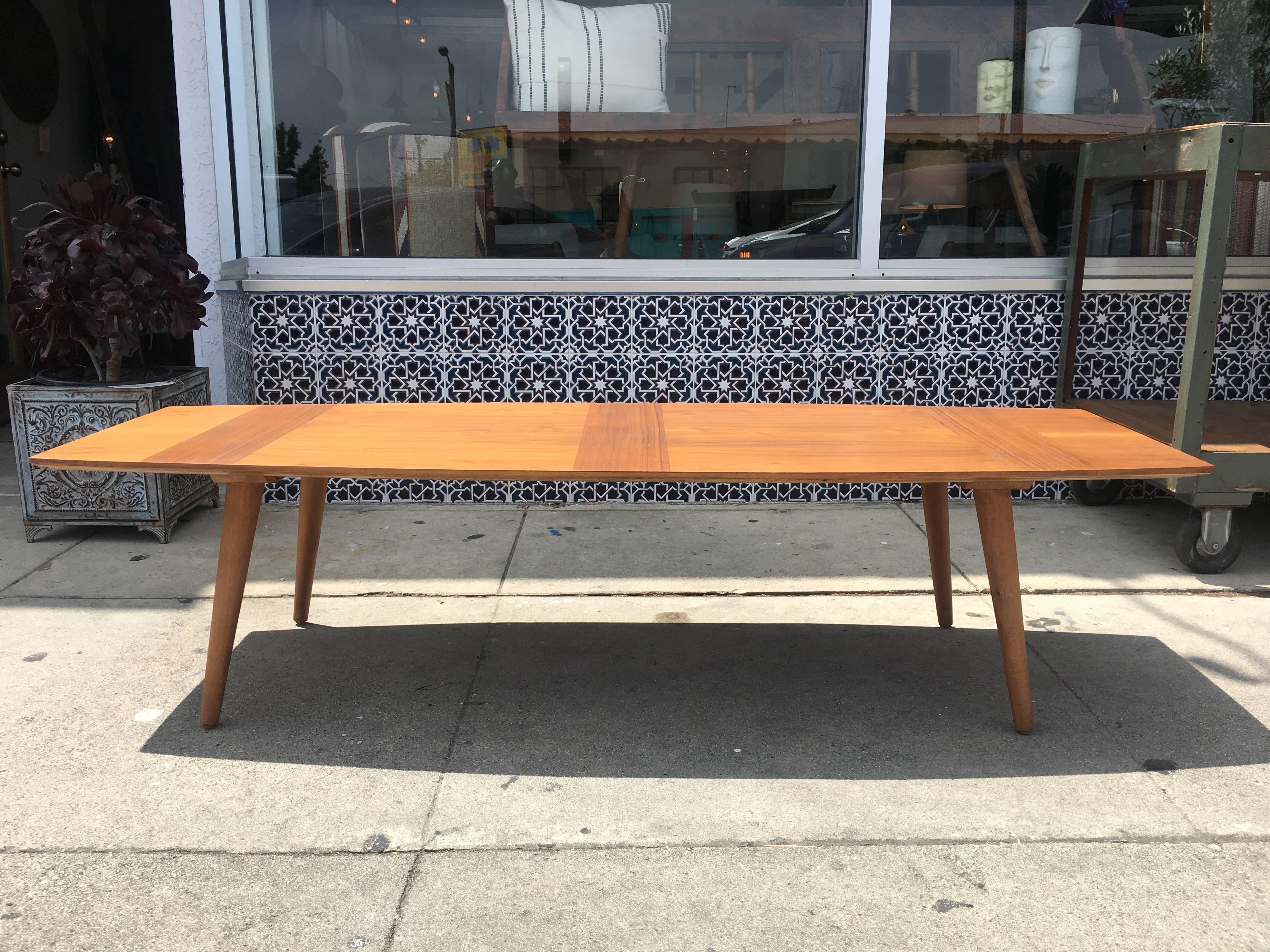 Long Mid-Century surfboard coffee table with beautiful wood grain details. Tapered peg legs.