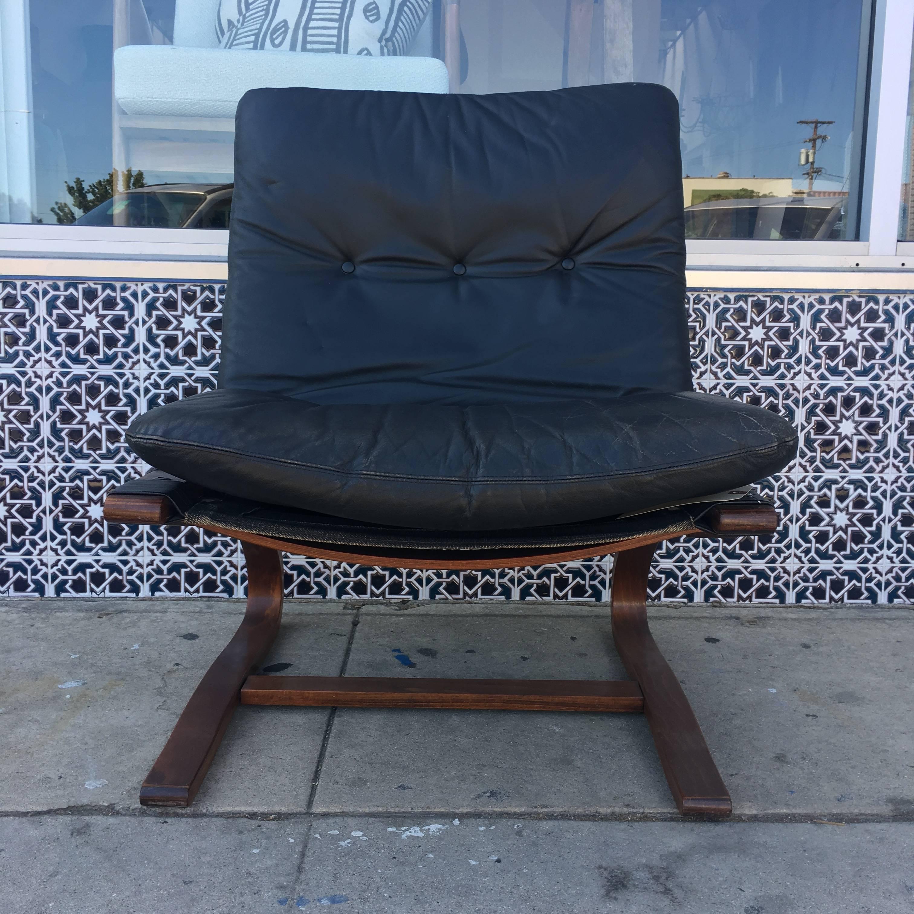Pair of Danish leather lounge chairs with removable black leather upholstery and cantilevered wooden frames. Measures: Seat depth 18
