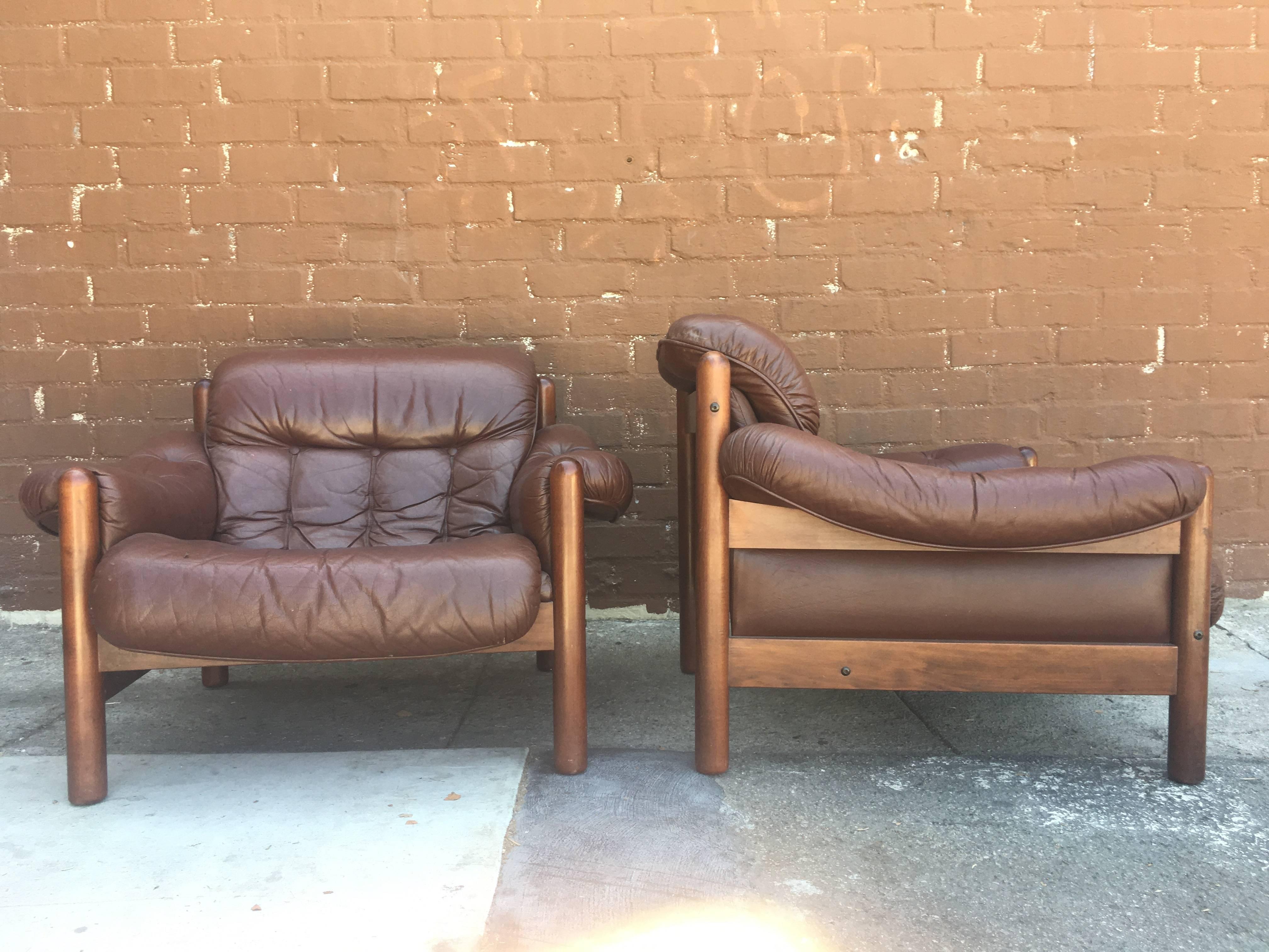 Pair of Swedish lounge chairs by Göte Möbler, circa 1960s-1970s. Comfortable button tufted cushions upholstered in beautifully aged brown leather, reminiscent of the infamous Percival Lafer style. Wood frames are in great condition.