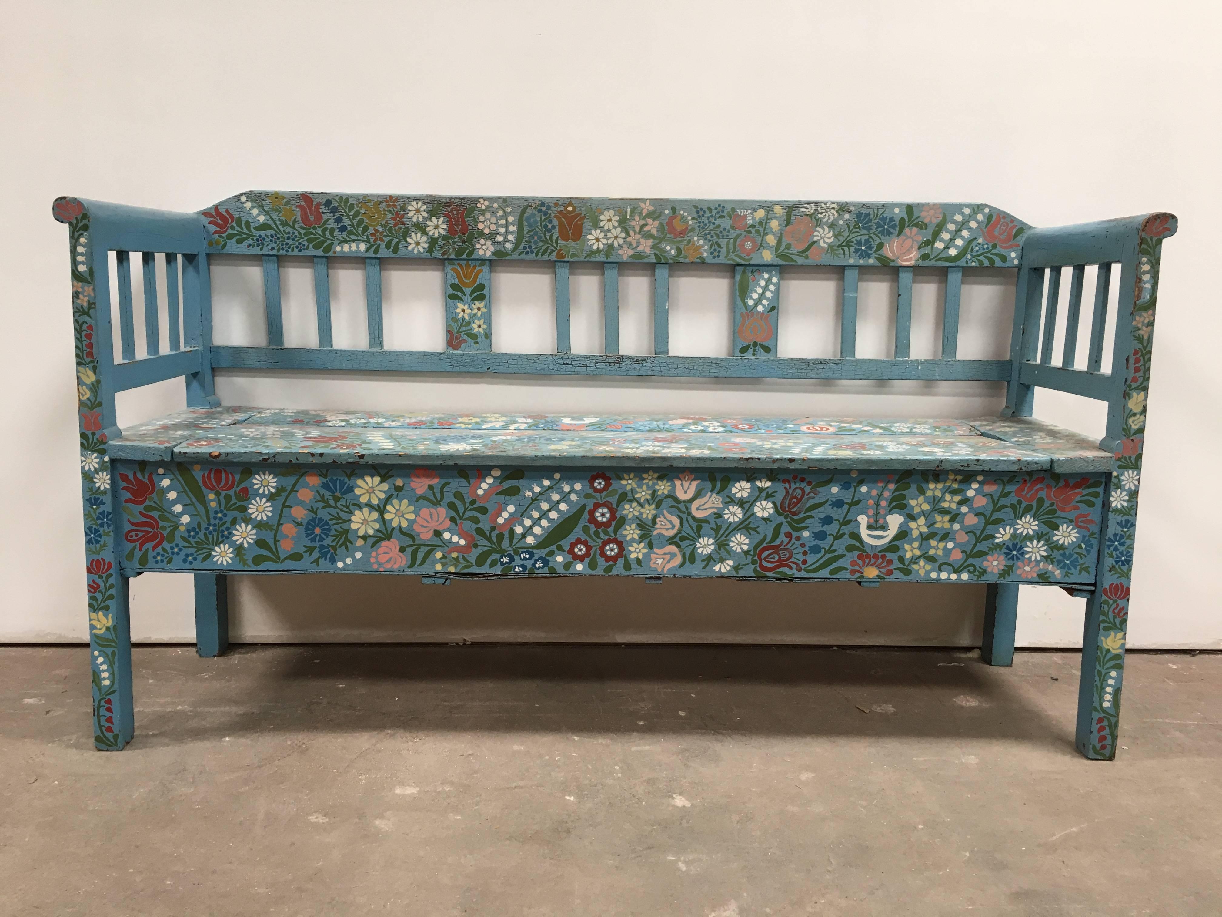 A beautiful European bench, hand-painted with flowers and birds, sourced from the French countryside. Features a 64