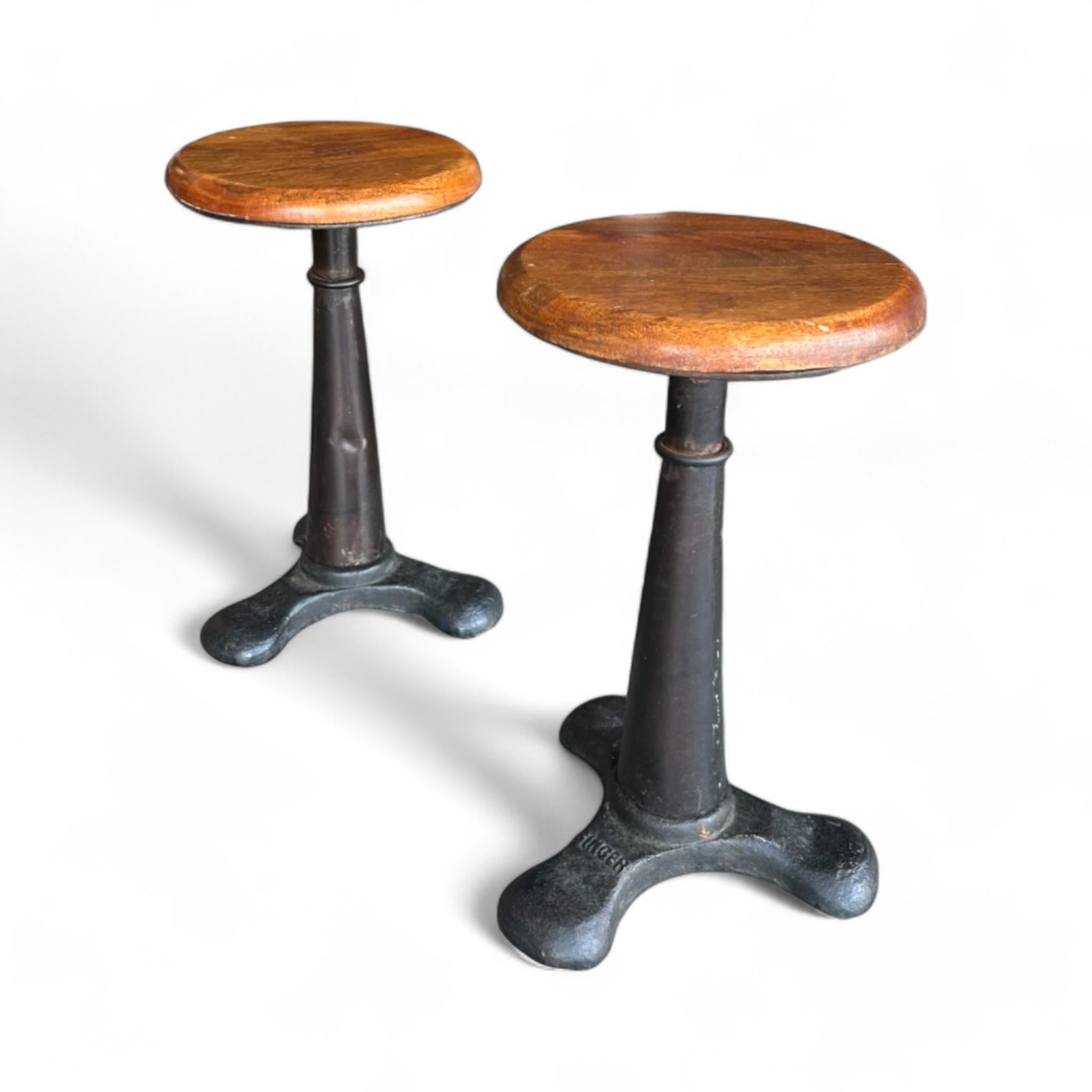 Original Singer industrial stools from the late 1950s to early 1960s, featuring a robust cast iron base and a beautifully curved timber seat with adjustable height. Originally used in European factories, these stools are perfect for adding a touch