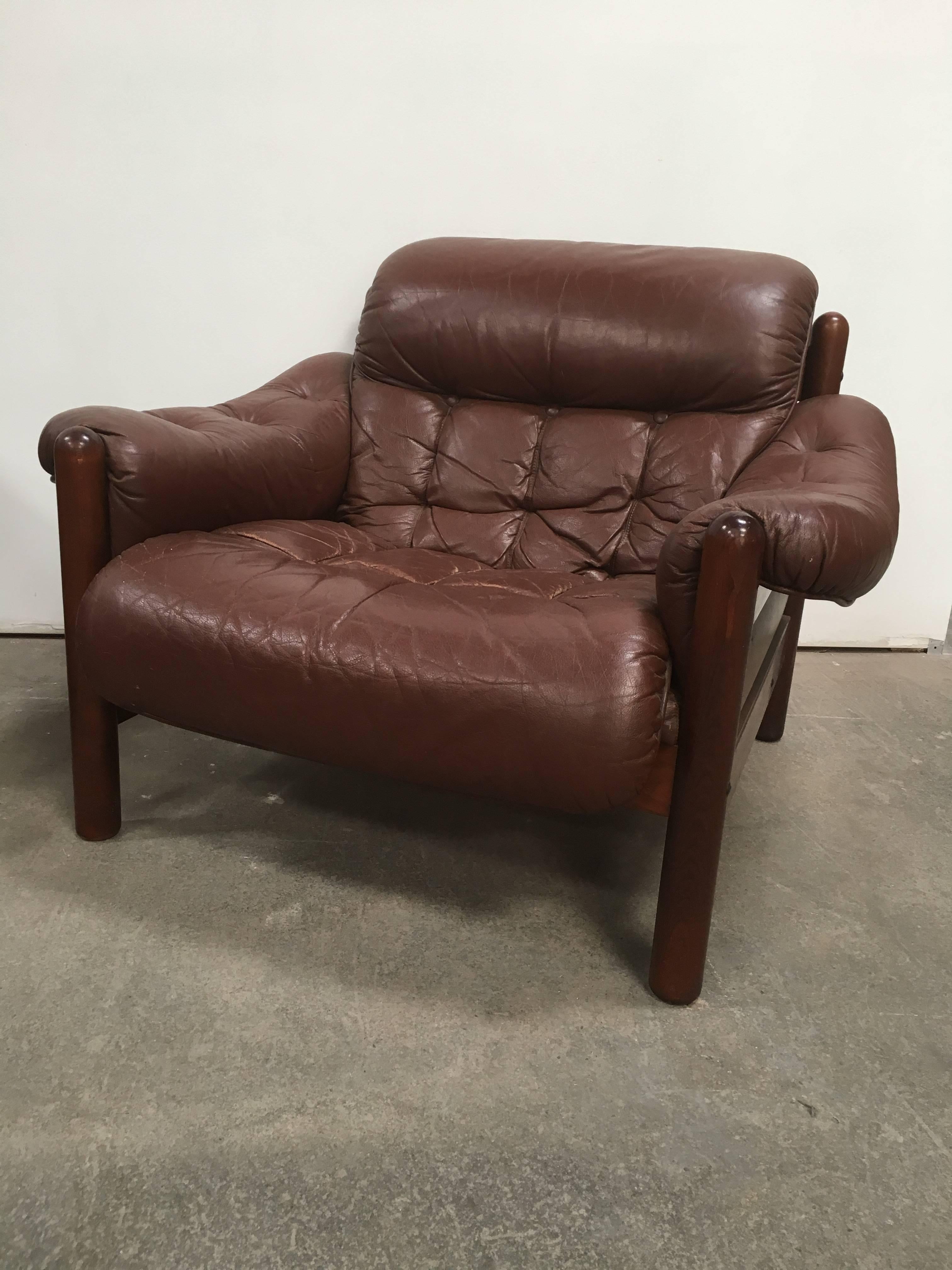 Pair of Swedish lounge chairs by Göte Möbler, circa 1960s-1970s. Comfortable button tufted cushions upholstered in beautifully aged brown leather, reminiscent of the infamous Percival Lafer style. Wood frames are in great condition.