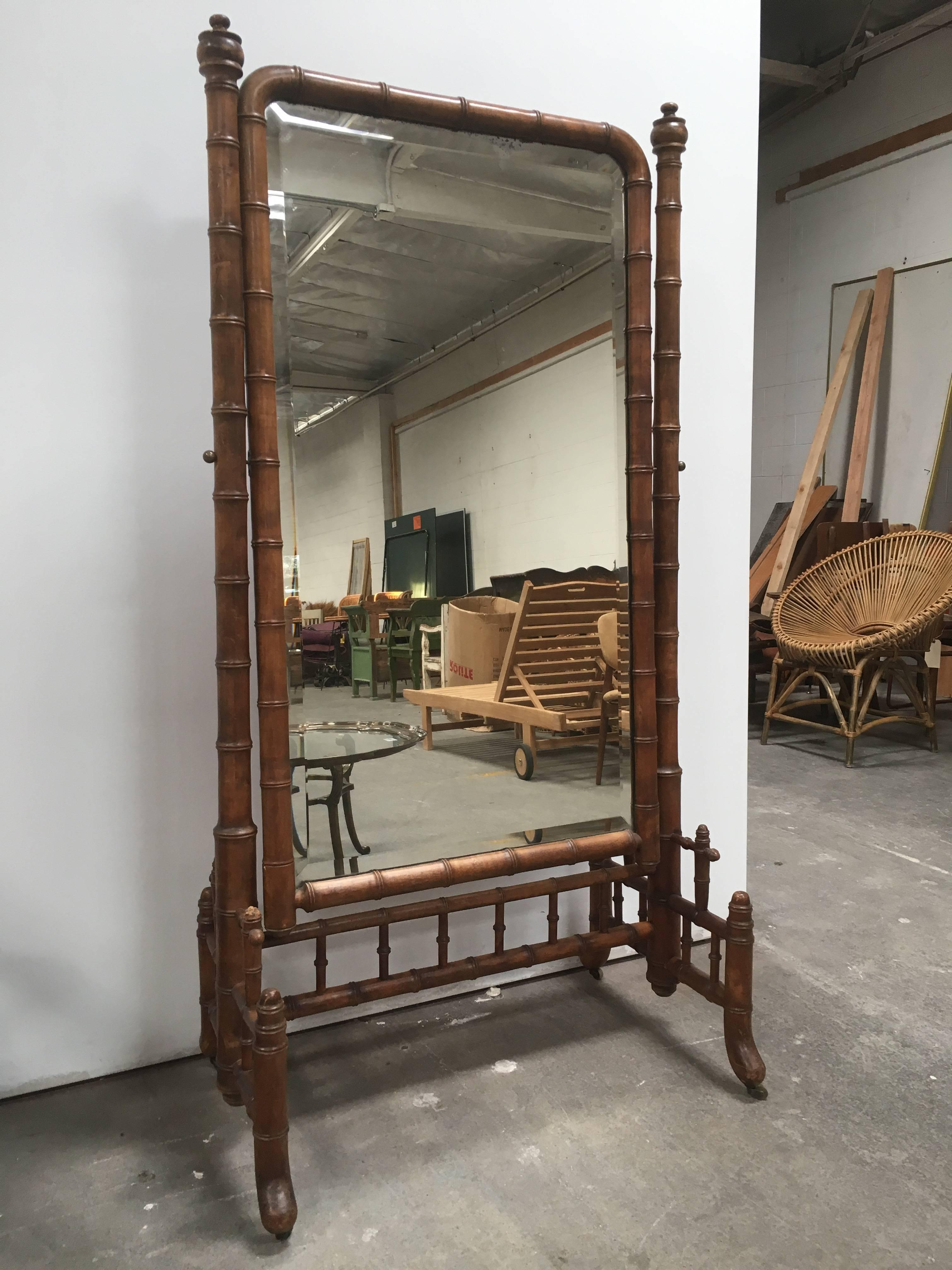 Beautiful faux bamboo cheval psyche full length mirror. Original brass hardware attaches mirror to rolling frame. Adds the perfect accent to you bedroom or dressing area.
 
   