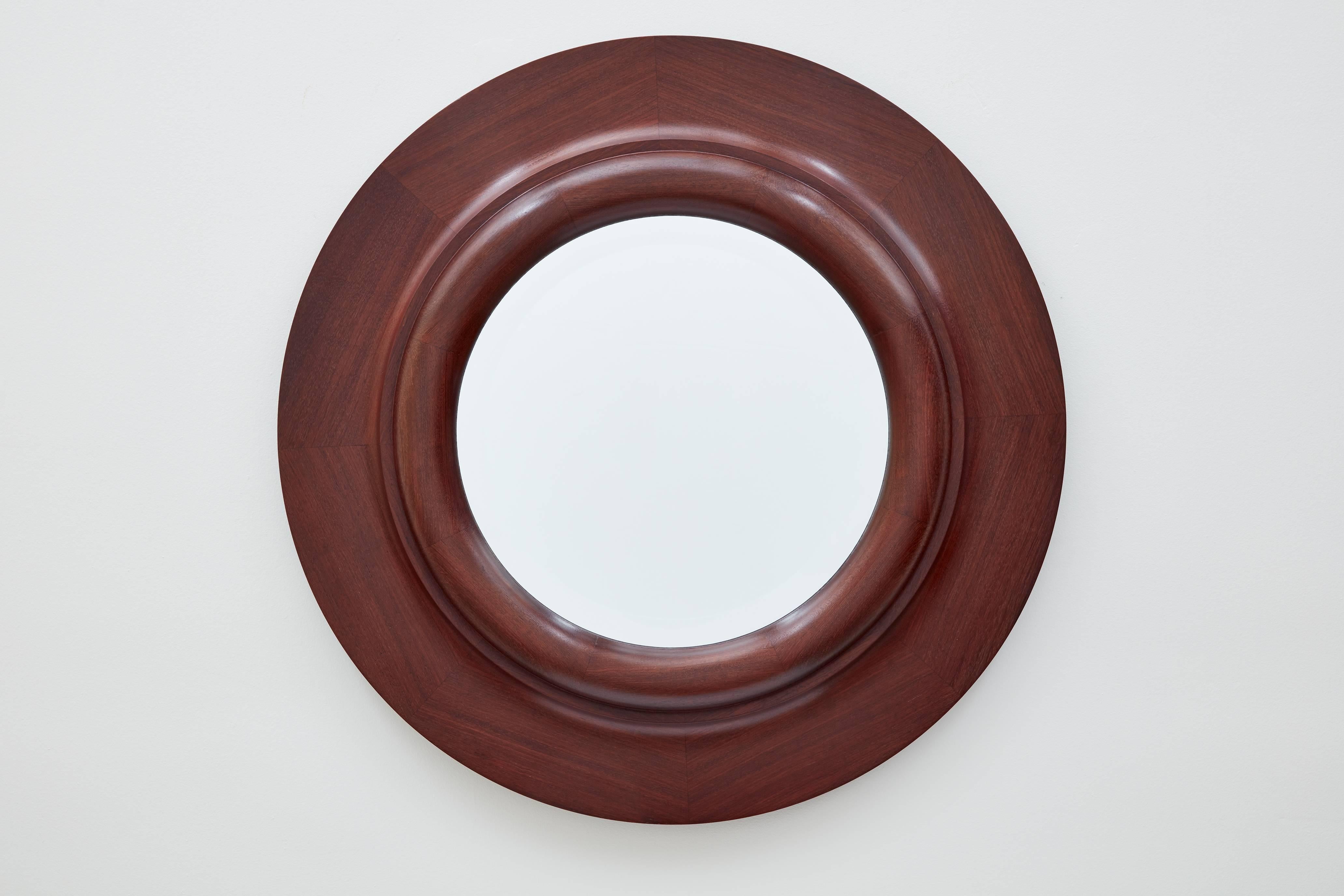 This circular wall mirror by Bark Frameworks was designed by rotating the base of a Doric column 90 degrees. The frame, created in the 1990s, was made from solid purpleheart wood -- a dense and rare species that becomes a deep chocolate purple as it