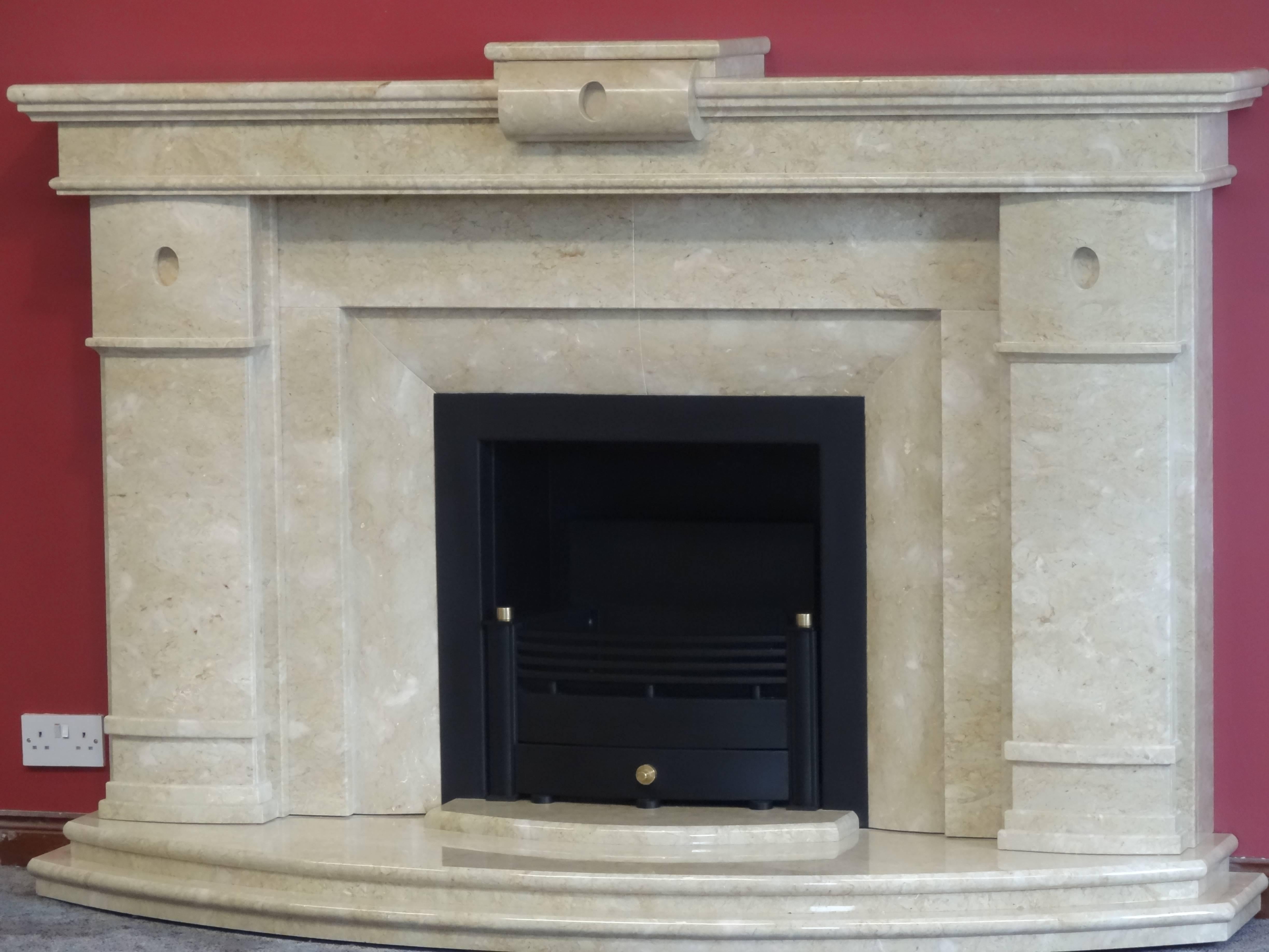 We created this contemporary design from polished Perlato Svevo marble.
This fireplace comprises of the matching marble hearth, metal trim built into the marble insert and the removable metal and brass fire basket.

Measurements:
Mantel 78