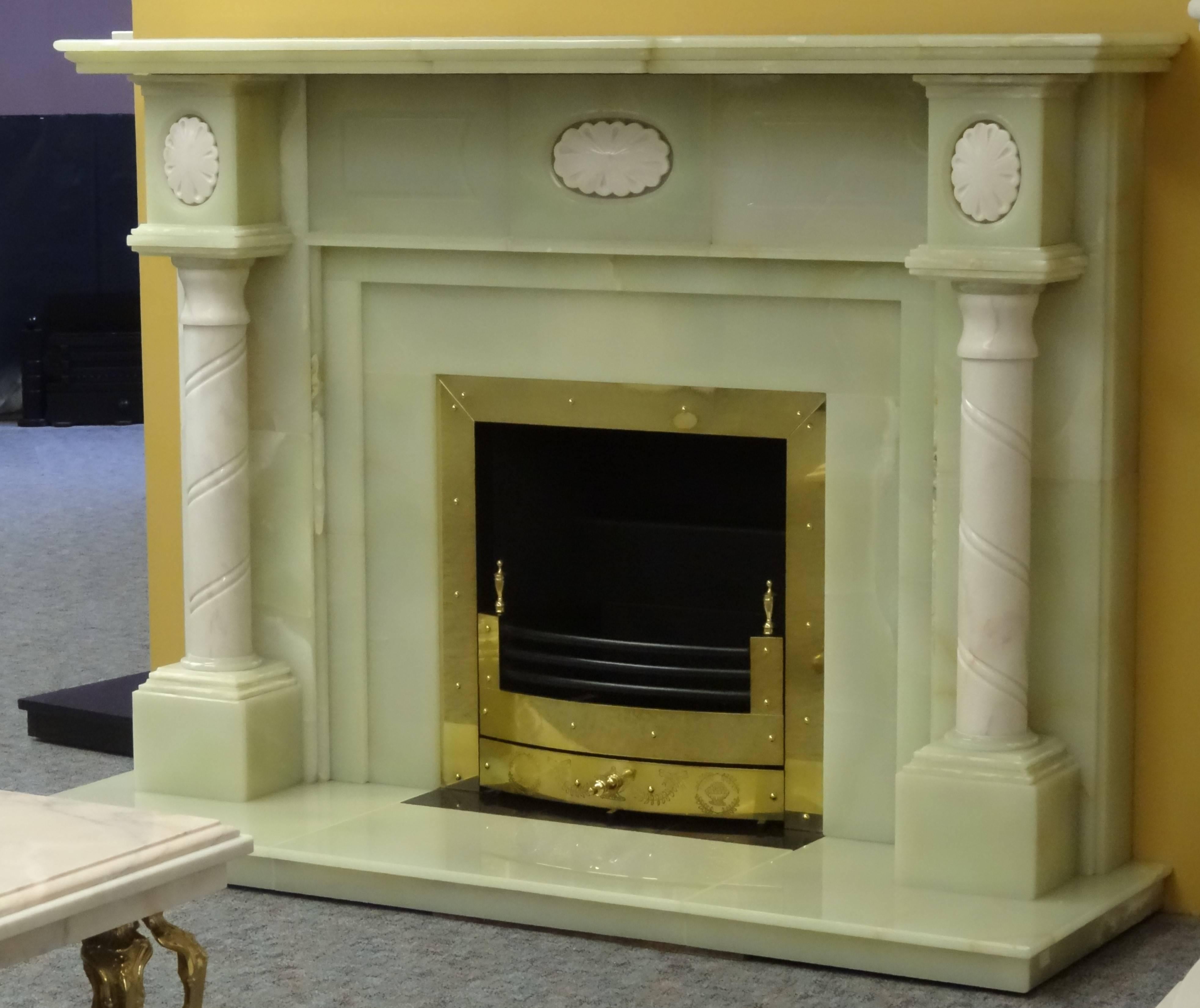 We created this Georgian style fireplace from beautiful semi precious green onyx slabs, the columns and cameos are carved from Rosa Aurora marble. The fireplace comprises of matching onyx hearth, onyx insert with built in satin finished brass frame