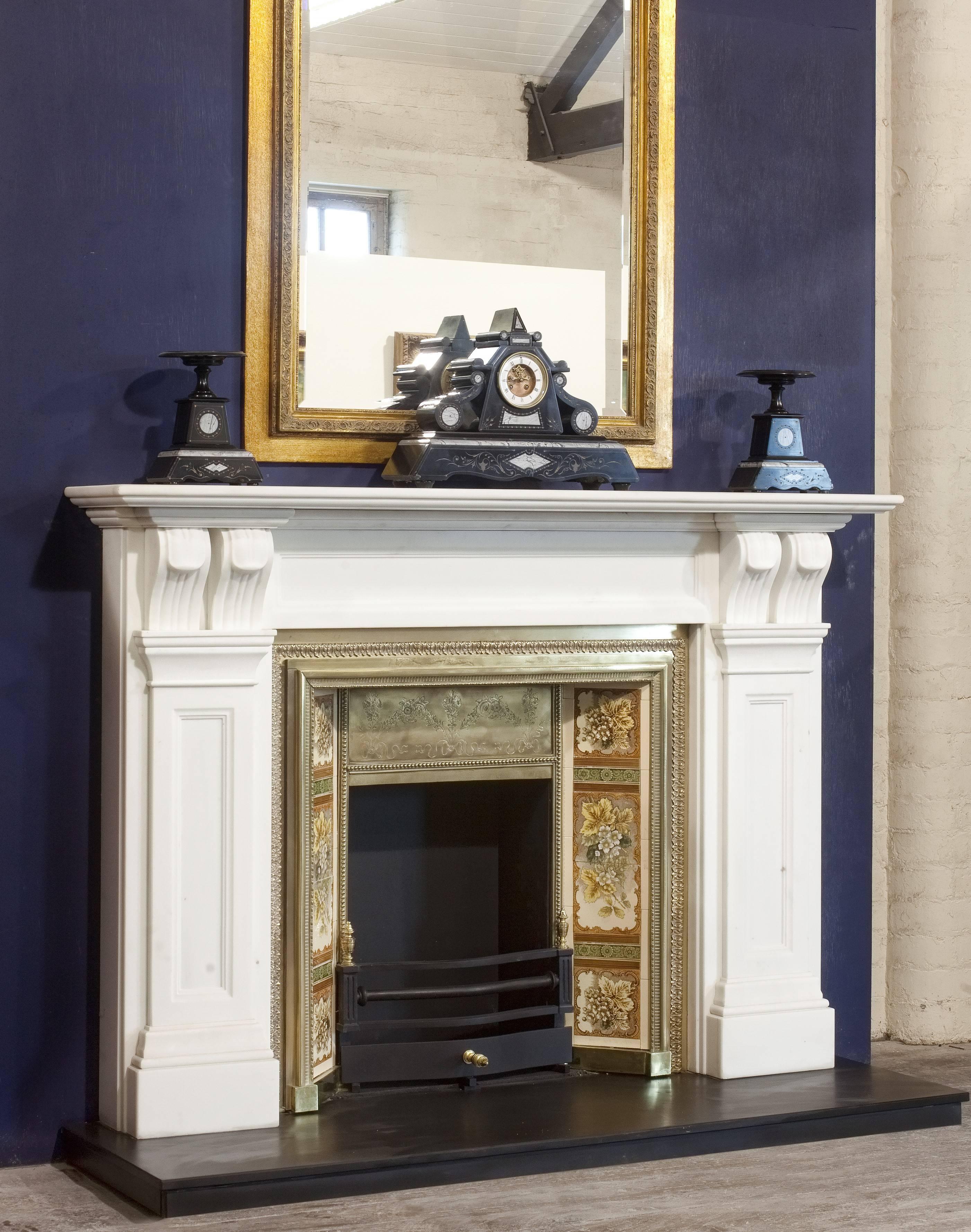 1930s reproduction of Victorian fire surround hand-carved in pure white marble.
This fire surround has hand-carved recessed panels on the frieze and pilaster jambs, the hand-carved twin corbels support a two-tier mantel.
The marble fireplace