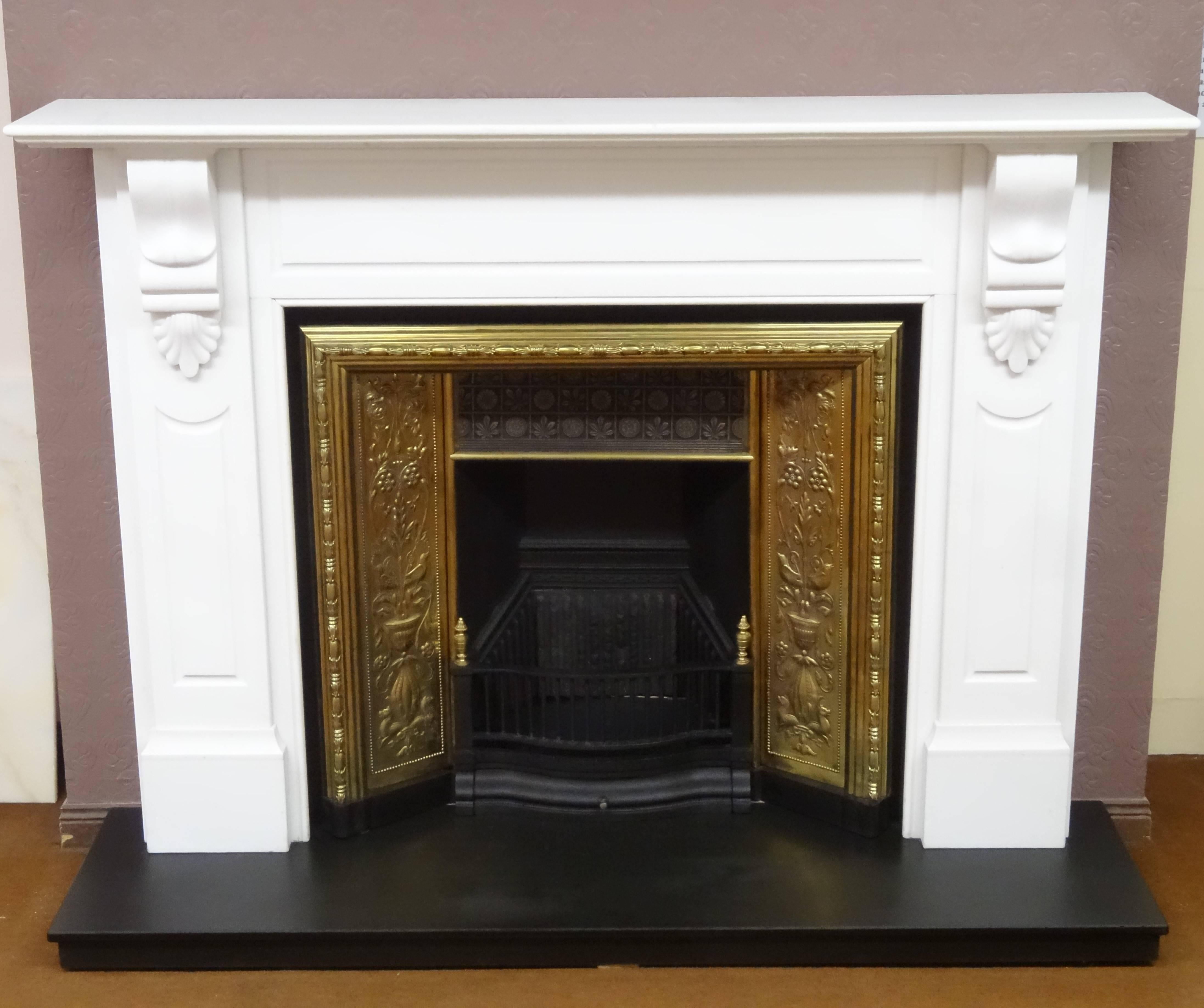 Early 20th century reproduction of Victorian Fire Surround in pure white marble. The Fire Surround has recessed panels on the frieze and jambs, hand carved corbels support a two tier mantel. The Fire Surround is complimented with a 19th century