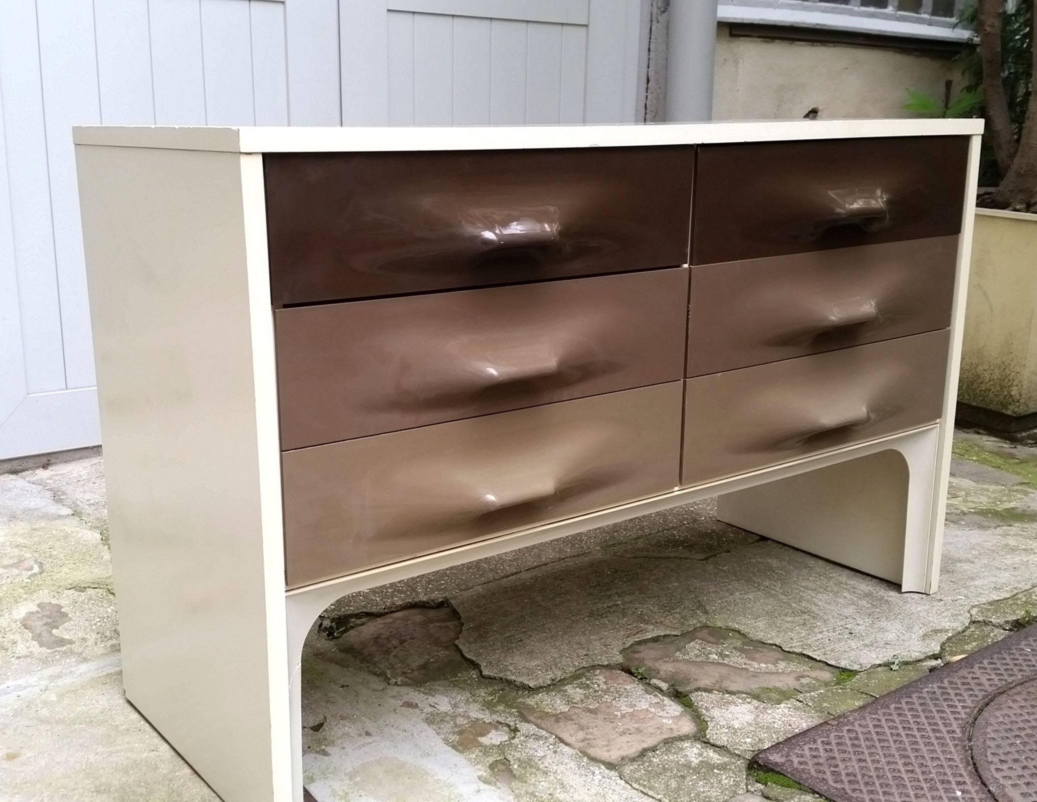 By opening, from bottom to top, by a flap opening out of a shoe locker, then a double drawer, two drawers and a shelf with a mirror bottom that forms a vanity in the upper part; an opening at the back accommodating a small rod. It rests on four