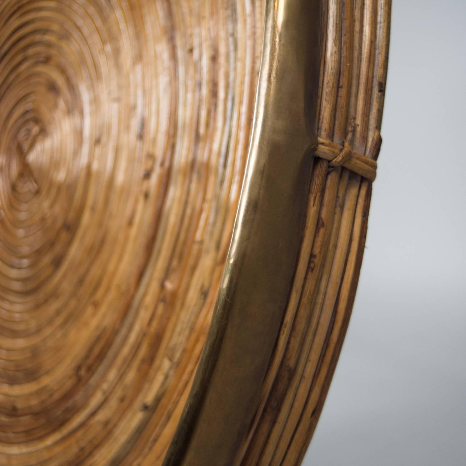Concentric circles of bamboo reeds formed into a tray with a brass edge detail.
