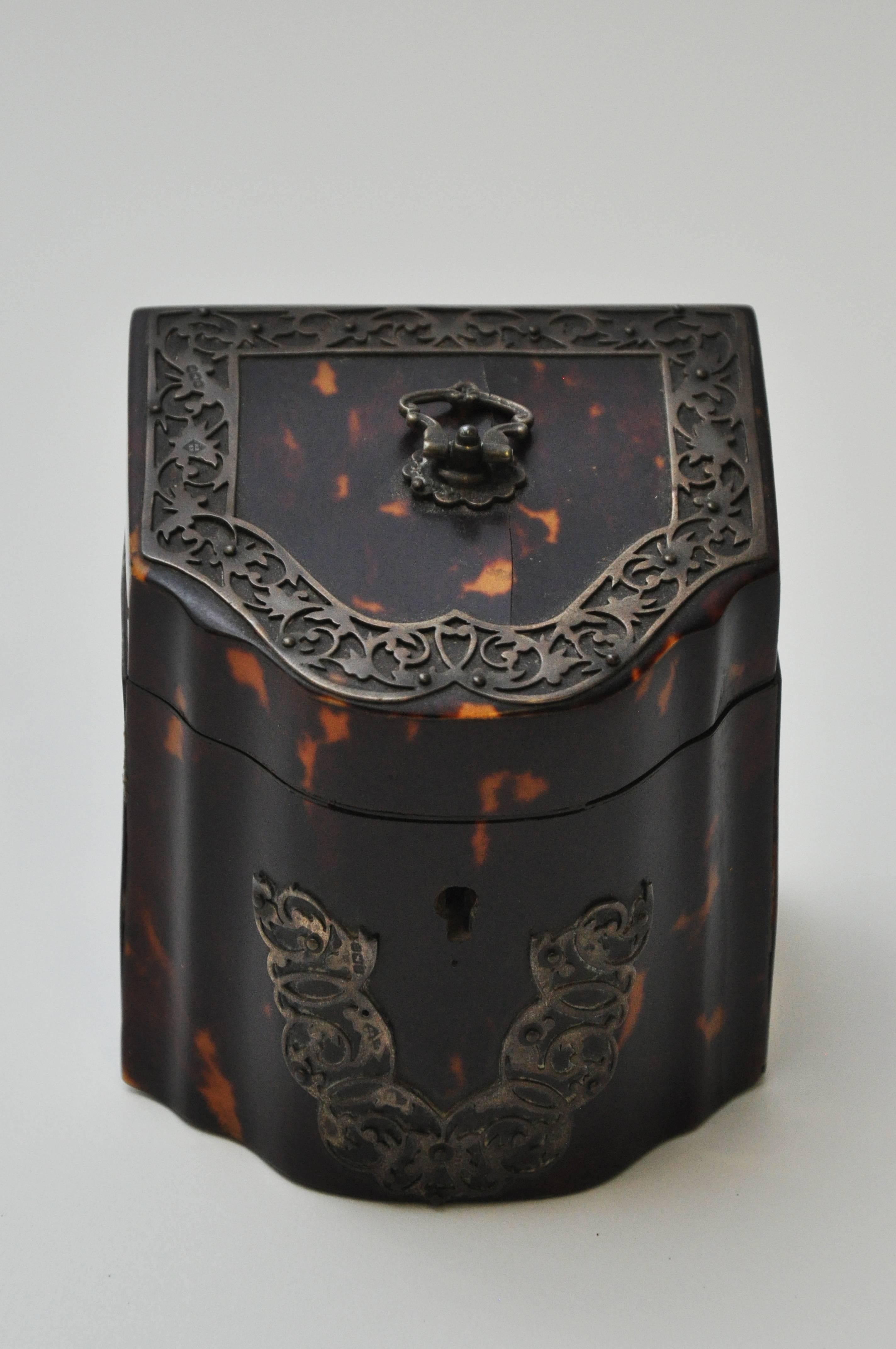 A uniquely-shaped rare 19th century tea caddy of tortoise shell with sterling silver decoration.