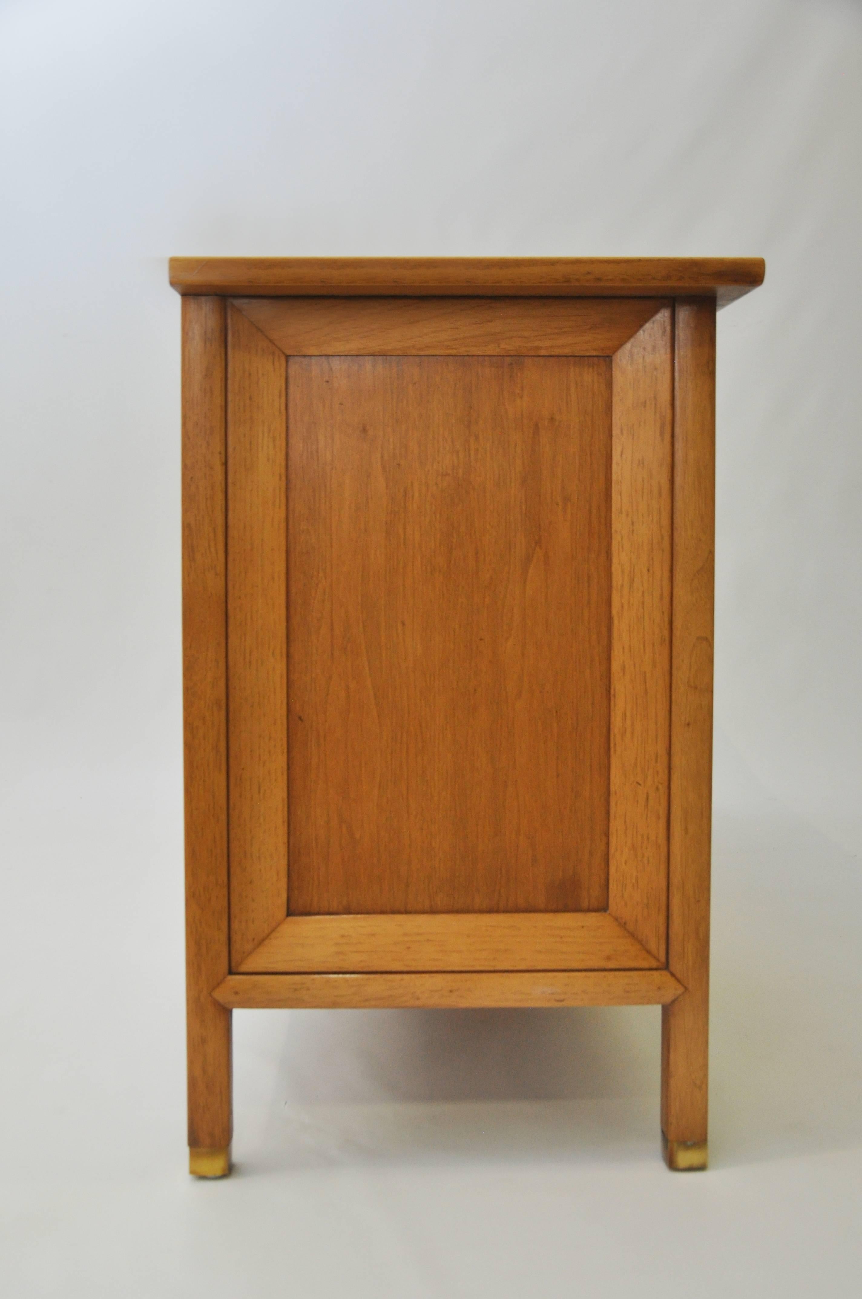 Part of Tomlinson's Sophisticate line, developed in the mid-1950s and continued throughout the 1960s. Beautiful pecan and butternut case, with inset burl Myrtlewood veneer doors. The three-panel doors fold back to reveal storage for glassware and
