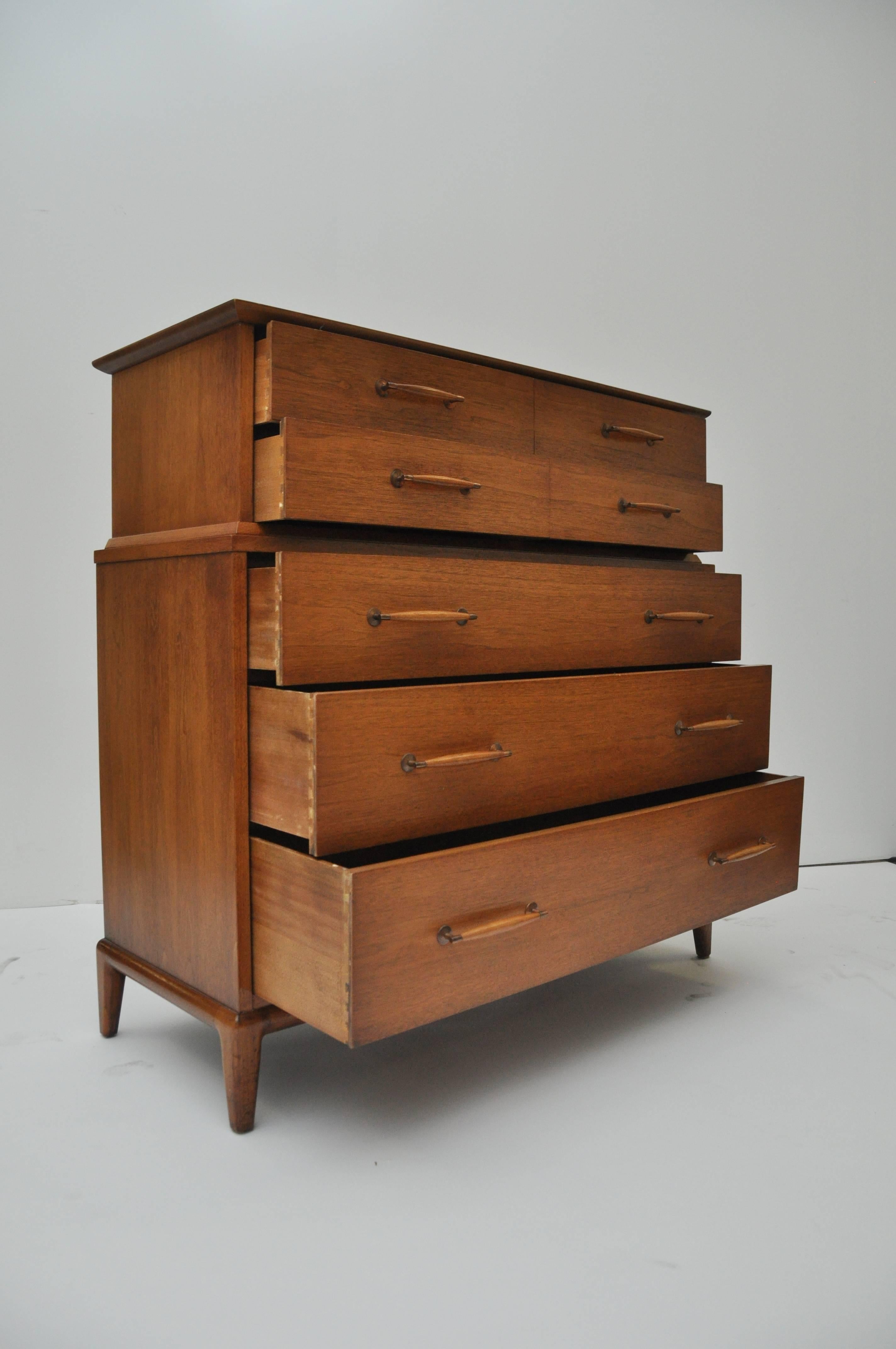 Chest has five drawers. It has copper and wooden hardware. Walnut with distinct grain and has two inset detailed wooden strips to accent the top.