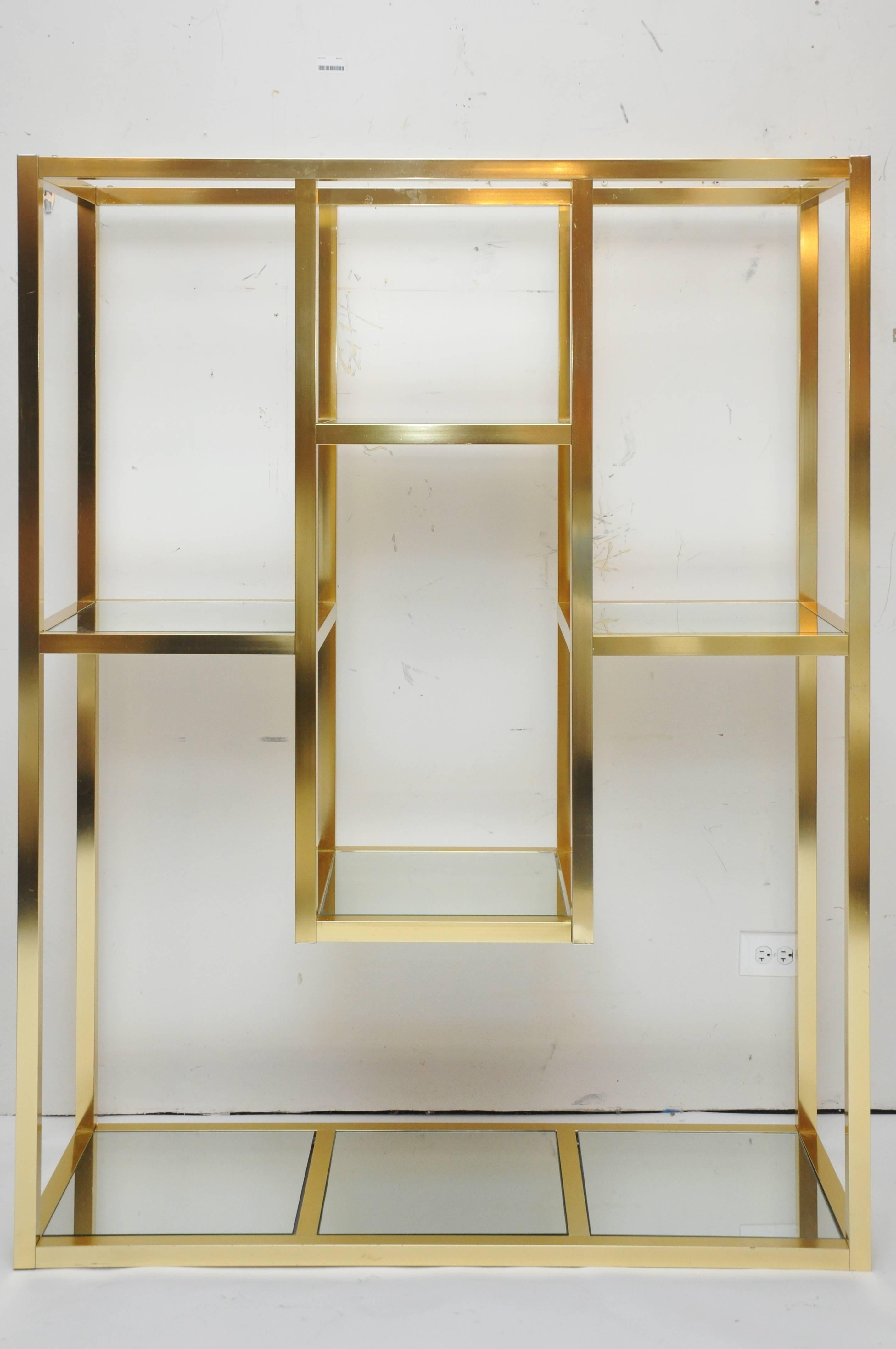 Mid-Century Modern brass etagere shelving unit with mirrored shelves.