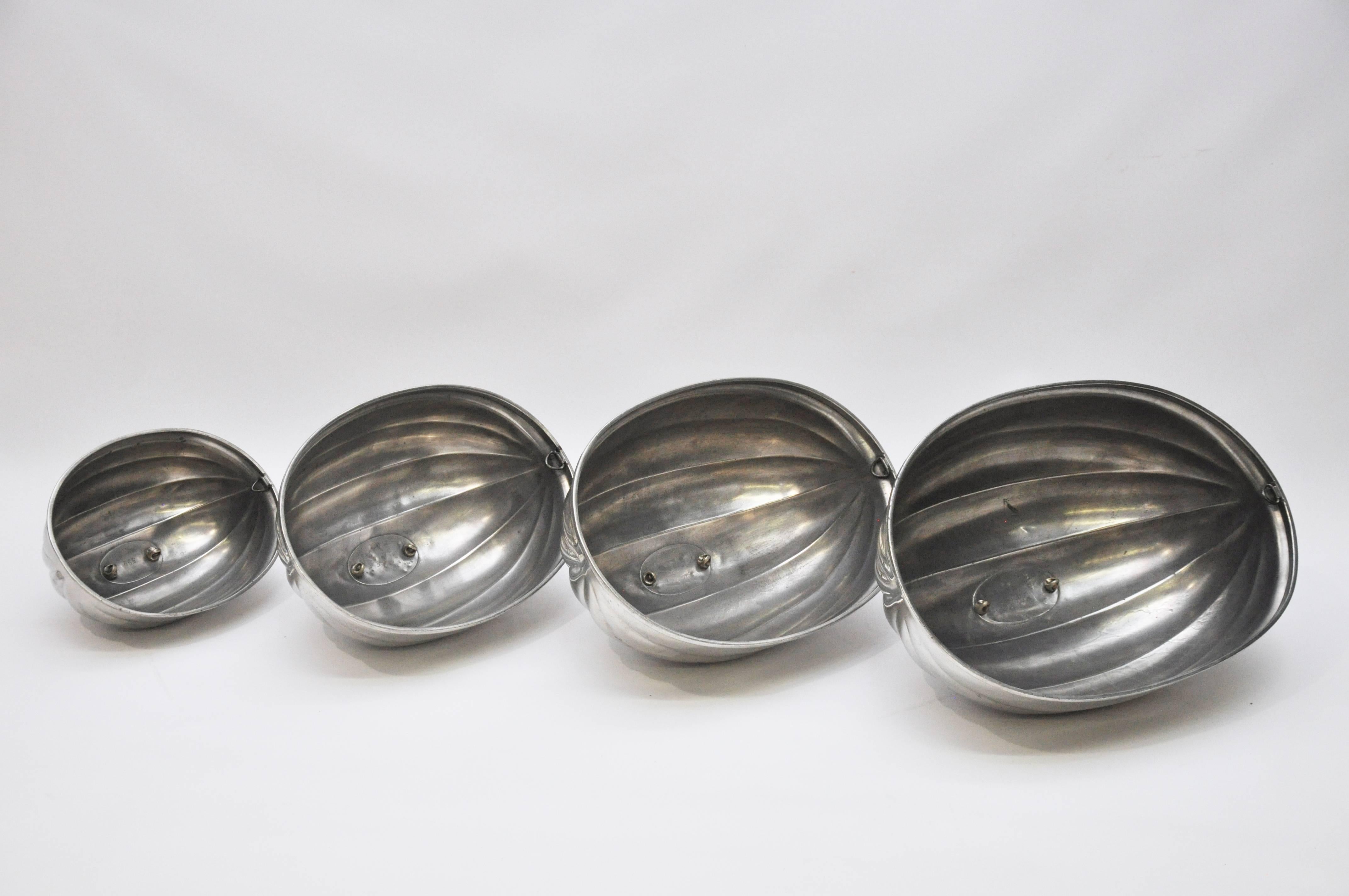 A rare survivor - a complete set of four graduated size meat or food domes, made in the late 19th century by the firm of James Dixon & Sons, Sheffield. Of polished pewter in a melon-ribbed form. Detachable handles are cast in the shape of twisted