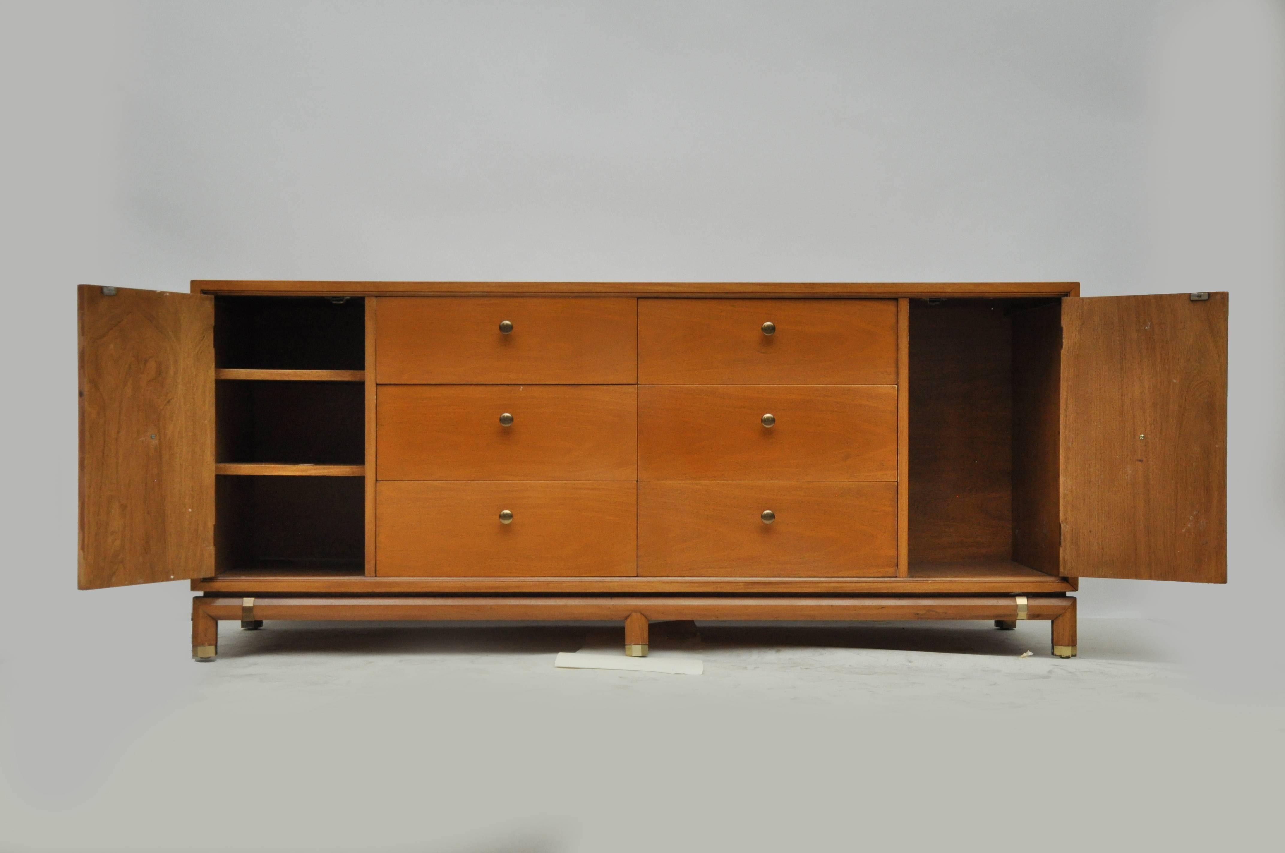Mid-Century Modern Kent Coffey light walnut veneer dresser. Dresser sits on tapered legs and has brass details. Chest has two doors for storage and six drawers.