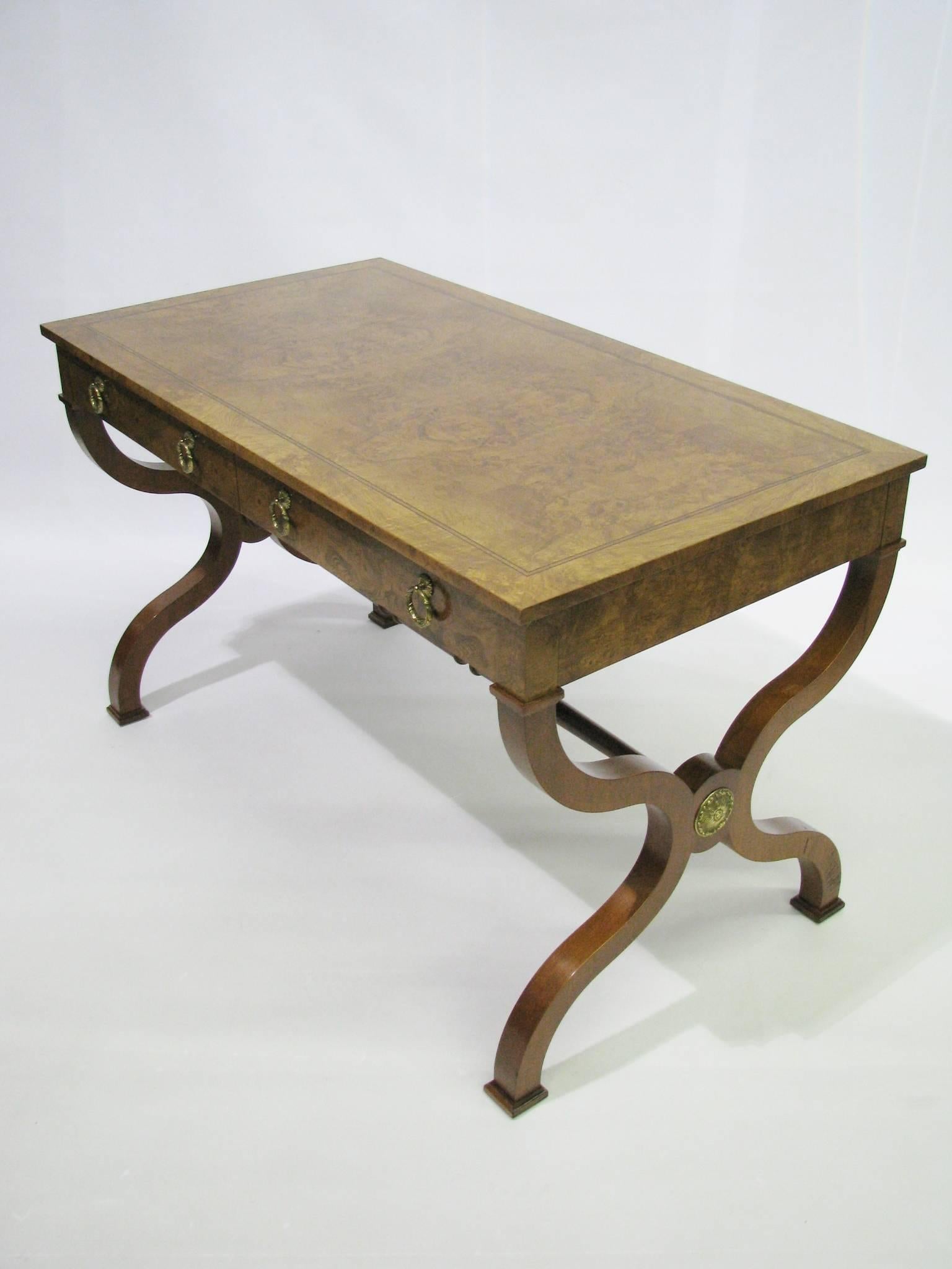 Beautiful and beautifully made Regency style writing desk or library table by Baker Furniture. Burl walnut veneers cover the top and all four sides of the case. The legs are solid hardwood. A contrasting band of ebonized stringing details the top's
