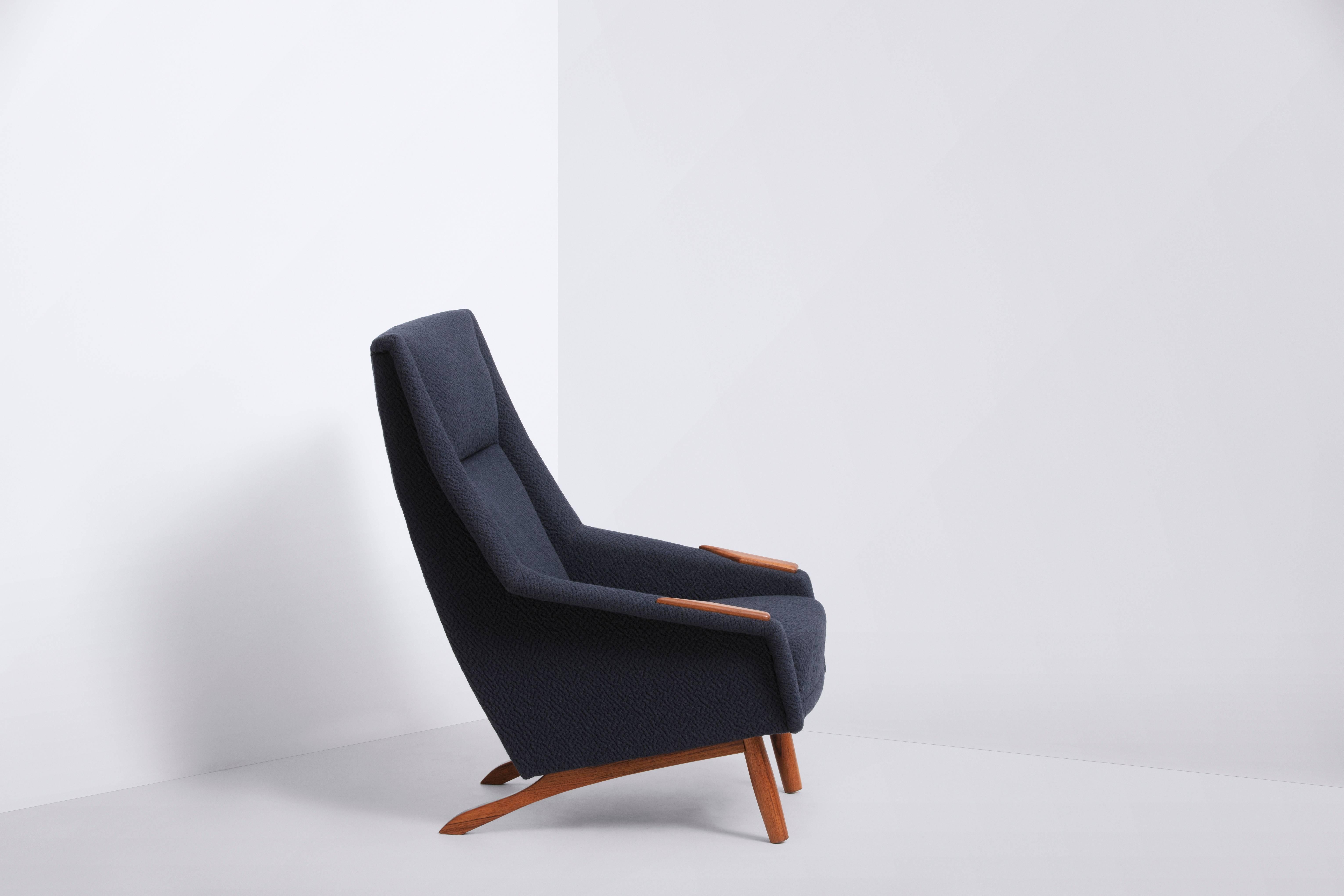This Danish produced lounge chair has a very comfortable, deep seating experience. The new Wool Upholstery by Kvadrat in dark navy is as stylish and fashionable now as it was in the 1960s. The exposed paws and legs are of solid teak wood and in good