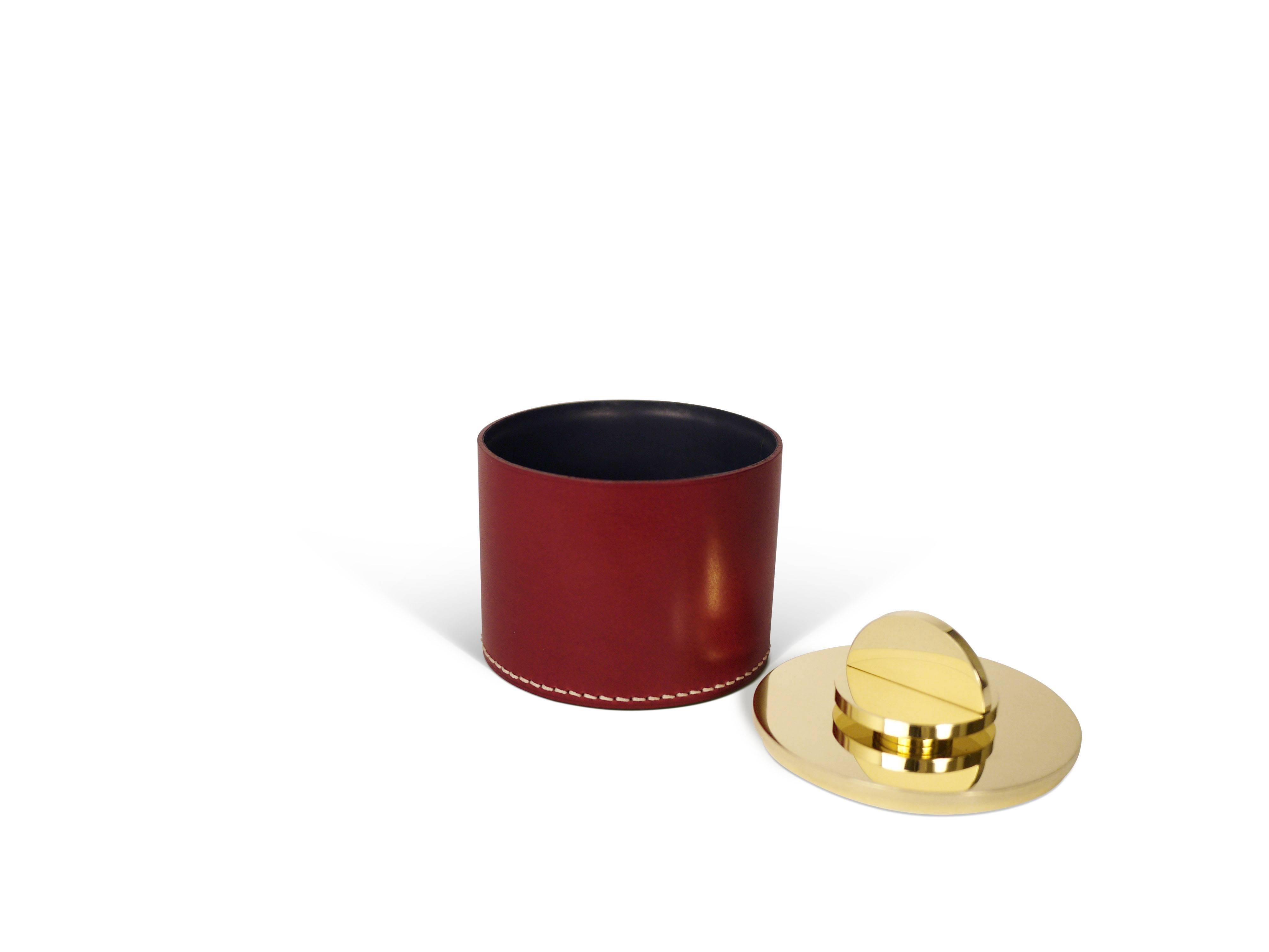 Part of Les Few's Armance collection, this contemporary, burgundy, round, leather and brass, modern, Minimalist box is made by artisans in Sweden. The interior leather comes in either anthracite gray or navy. The brass is solid Swedish brass and the