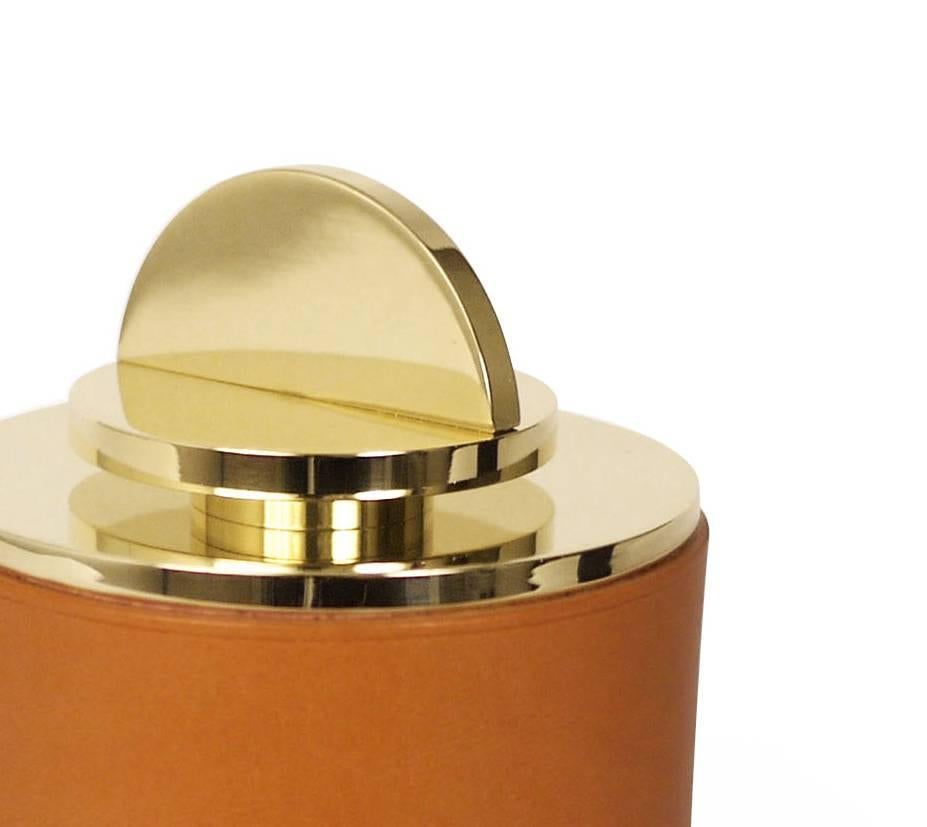 Part of Les Few's Armance collection, this contemporary, cognac colored, round, leather and brass, modern, Minimalist box is made by artisans in Sweden. The interior leather comes in navy. The brass is solid Swedish brass and the Italian leather is