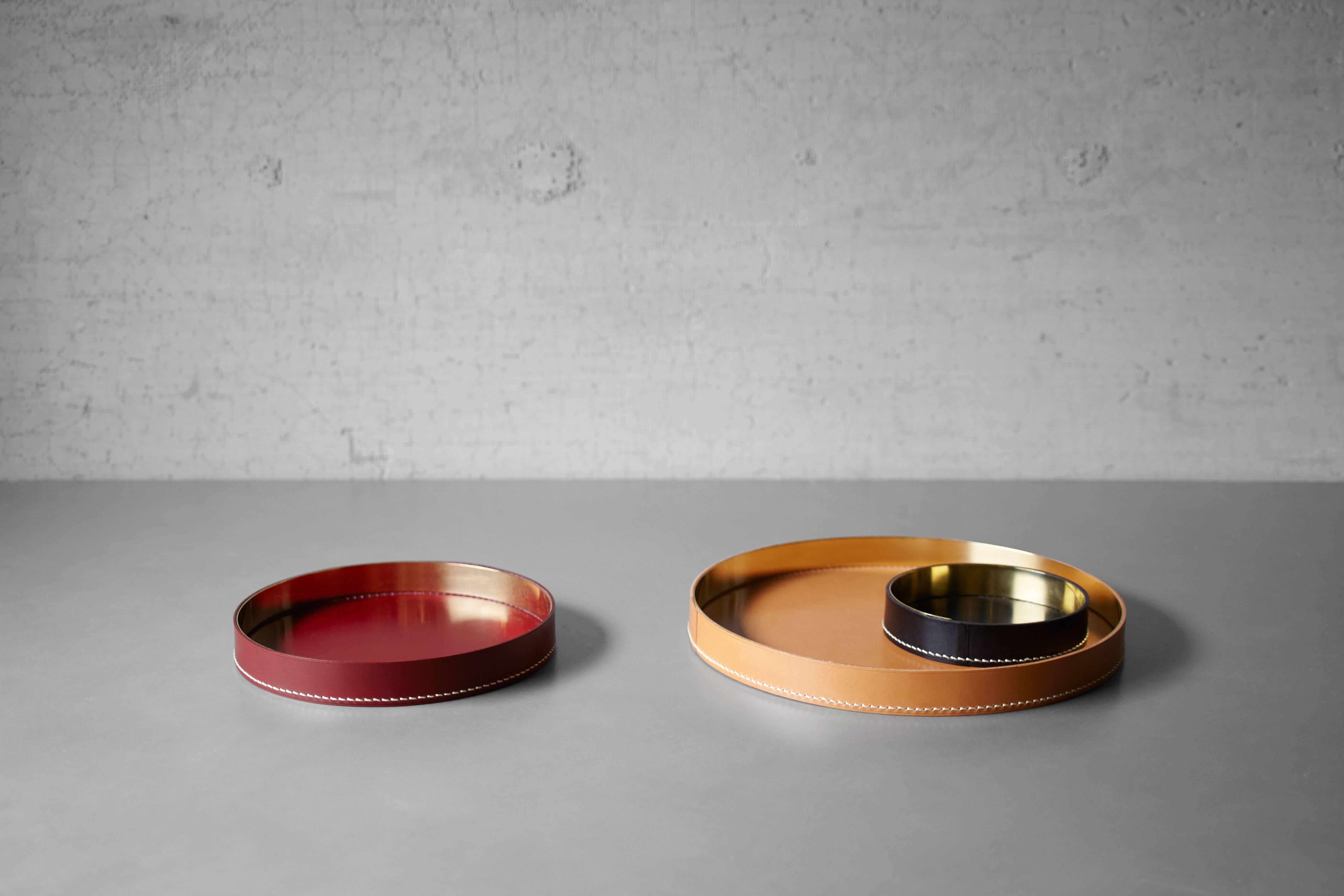 Part of Les Few's Armance collection, this contemporary, cognac colored, round, leather and brass, modern, Minimalist tray or centerpiece is made by artisans in Sweden. The leather comes in cognac, but can be special ordered in black or burgundy.