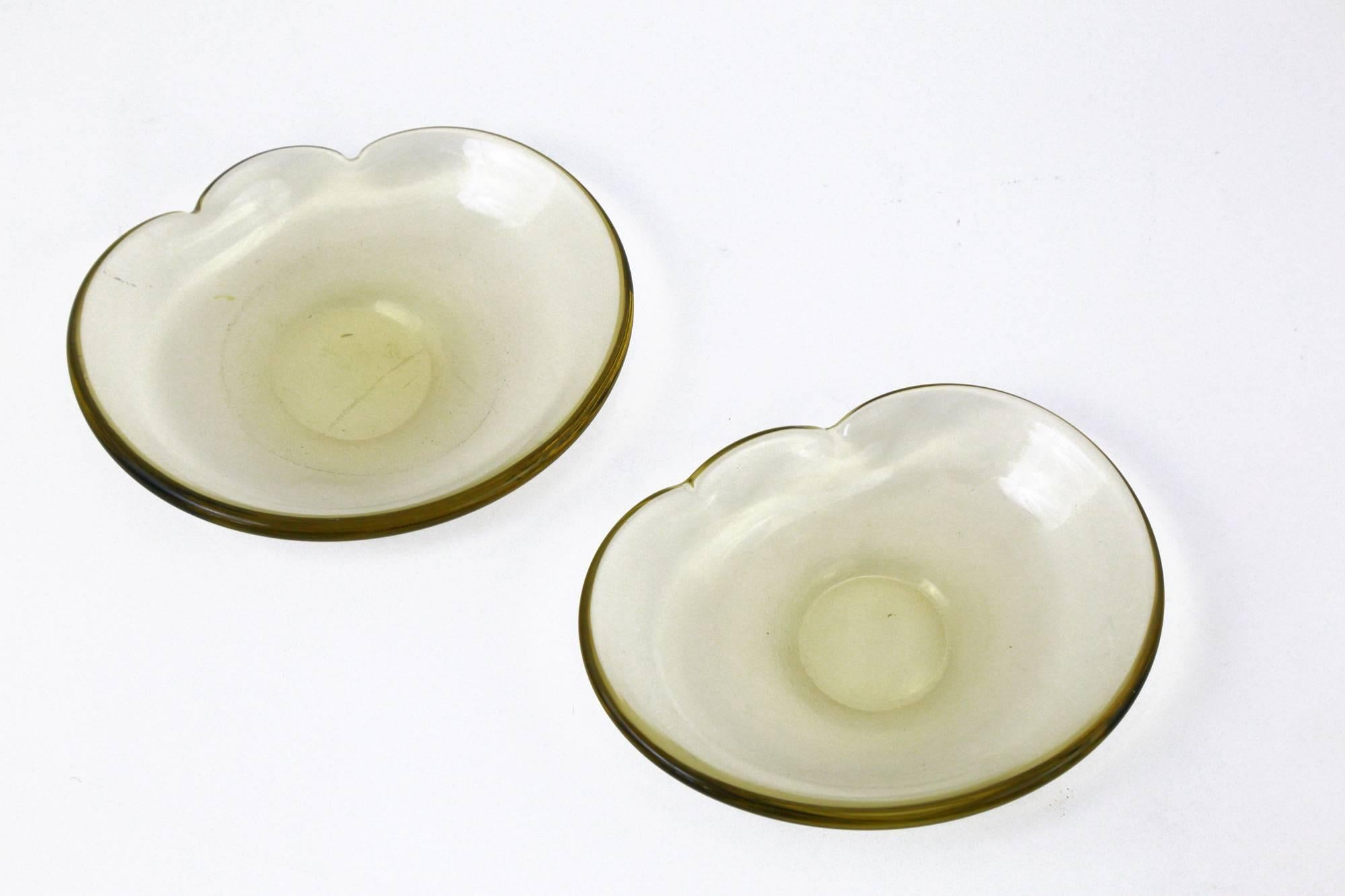 A pair of circa 1930 'pagliasco' glass dishes by the architect and designer Carlo Scarpa for the amazing Italian glass manufacturer, Venini. Oval in shape with a chic yello/green hue, these beautiful hand blown dishes each feature two stylish