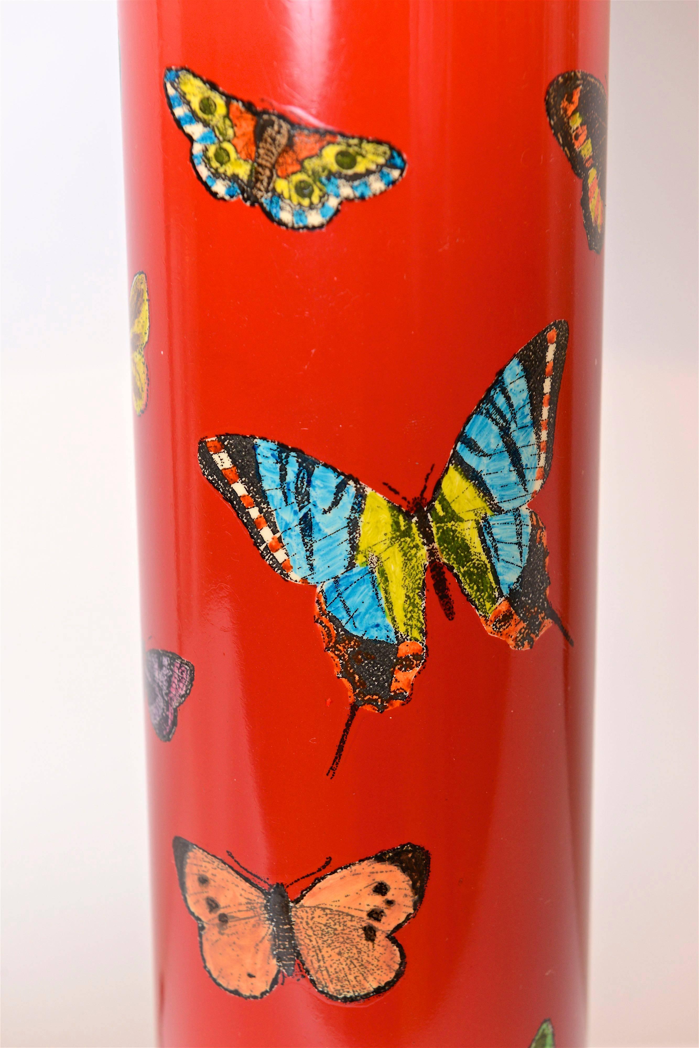 A beautiful and rare, circa 1950 table lamp with ‘butterfly’ motif by designer, Piero Fornasetti. Featuring various colored butterflies, these wonderful lacquered transfers sit on a scarlet red background and compliment the lamps brass detailing.