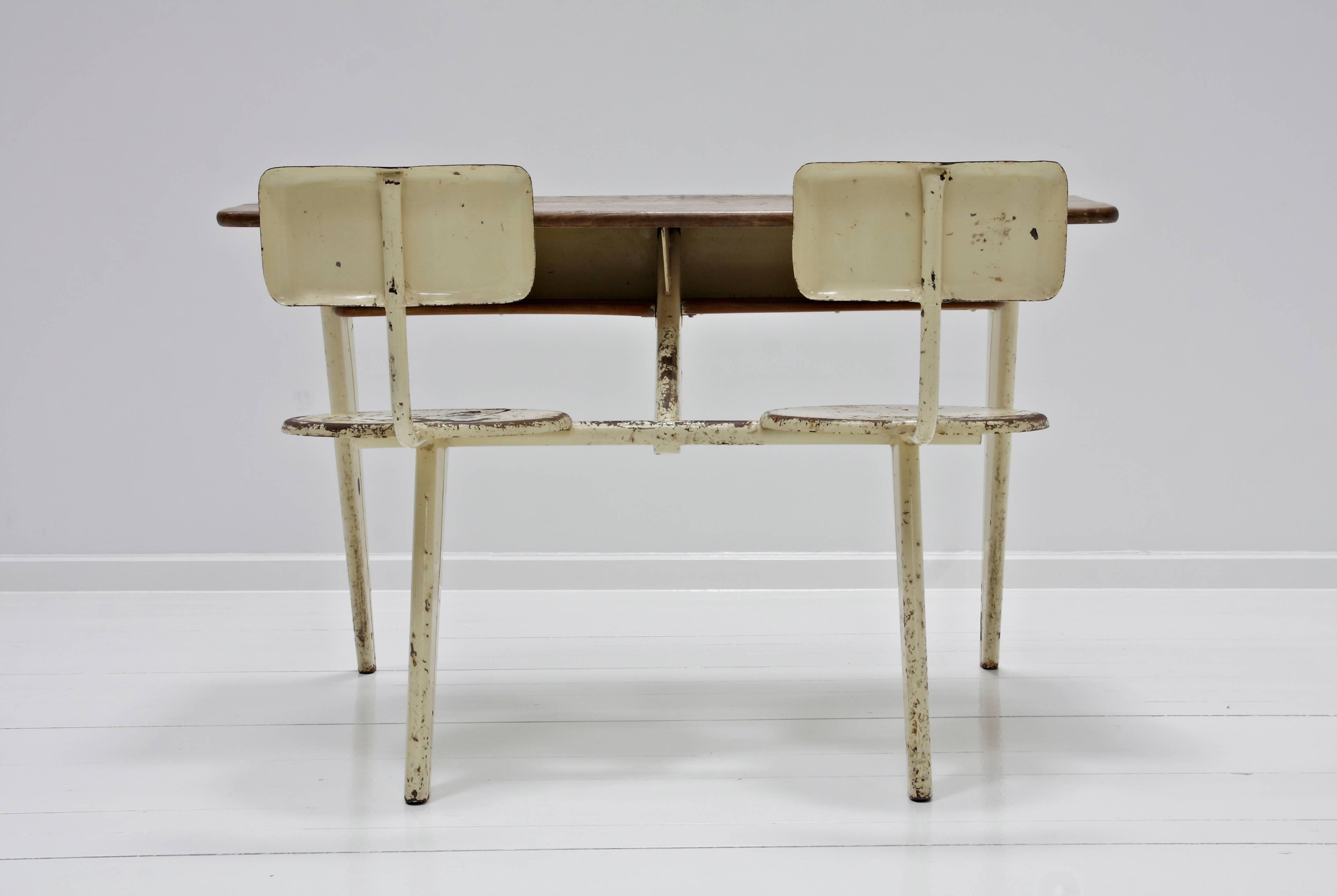 Scolastic furniture PP11 designed by Jean Prouvé. A seater-desk with a folded and lacquered steel sheet support and a solid wood top, 
circa 1940, France.
  