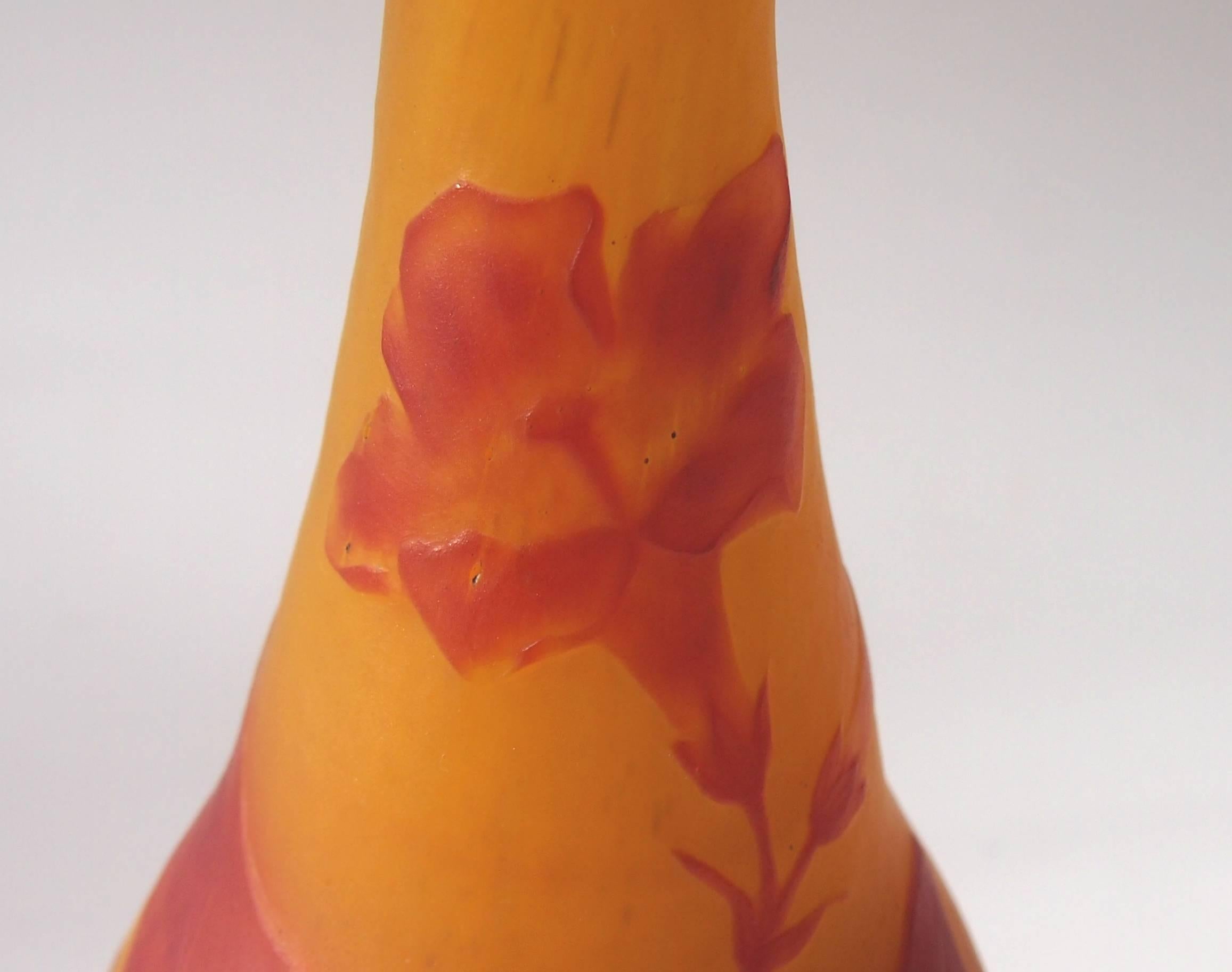 A super Daum Art Nouveau vase depicting the Nicotiana (Tobacco) plant in red over orange -beautifully signed. It employs all three of the most sophisticated techniques used by Daum at the time. The lower part with the base of the plant is executed