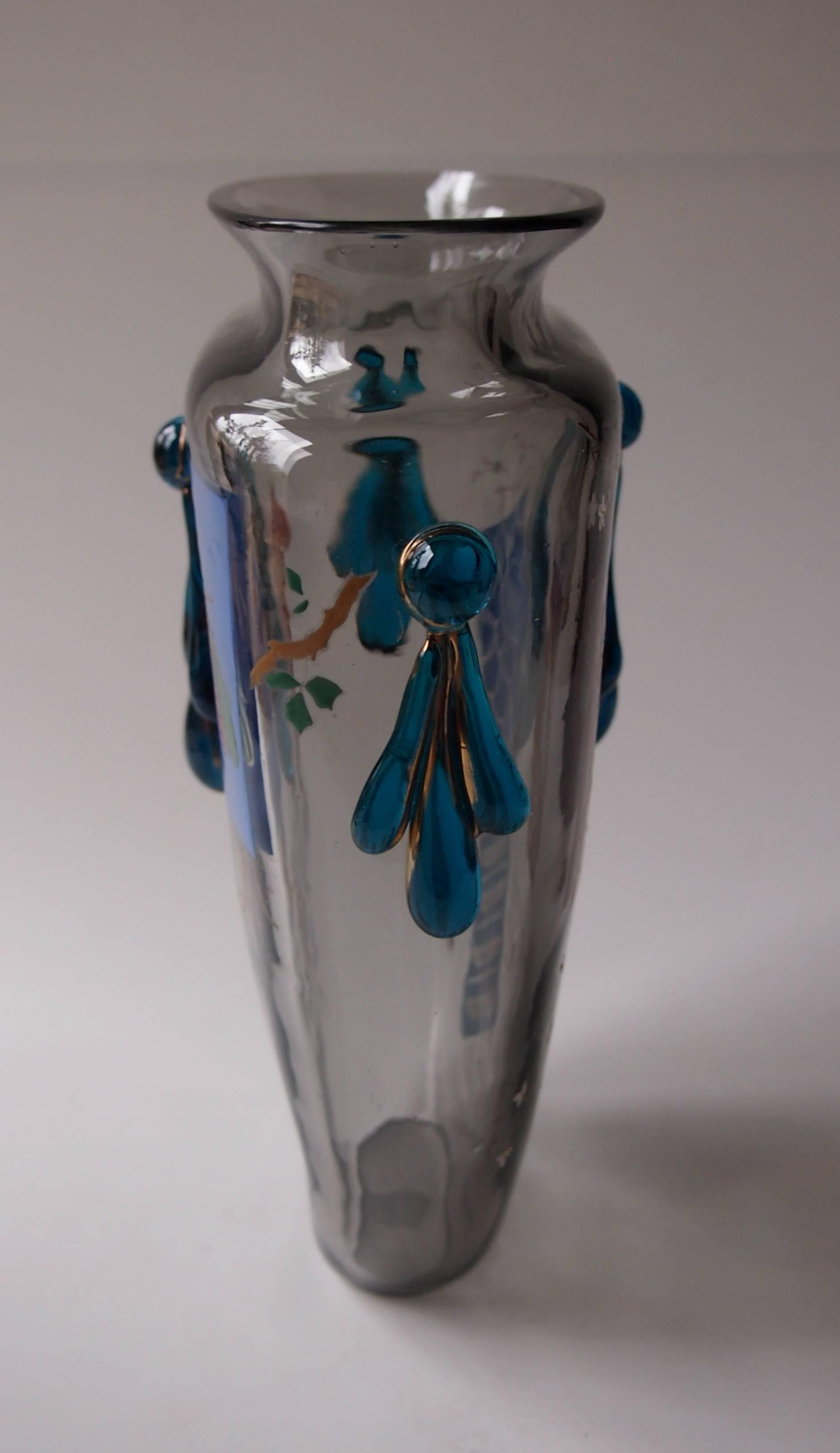 Stunning grey flattened form vase by Harrach in the Japonisme style decorated with enamel cartouches depicting insects and other oriental design imagery. With hot applied blue gilded swag decorations

Harrach has been the backbone of Bohemian, and