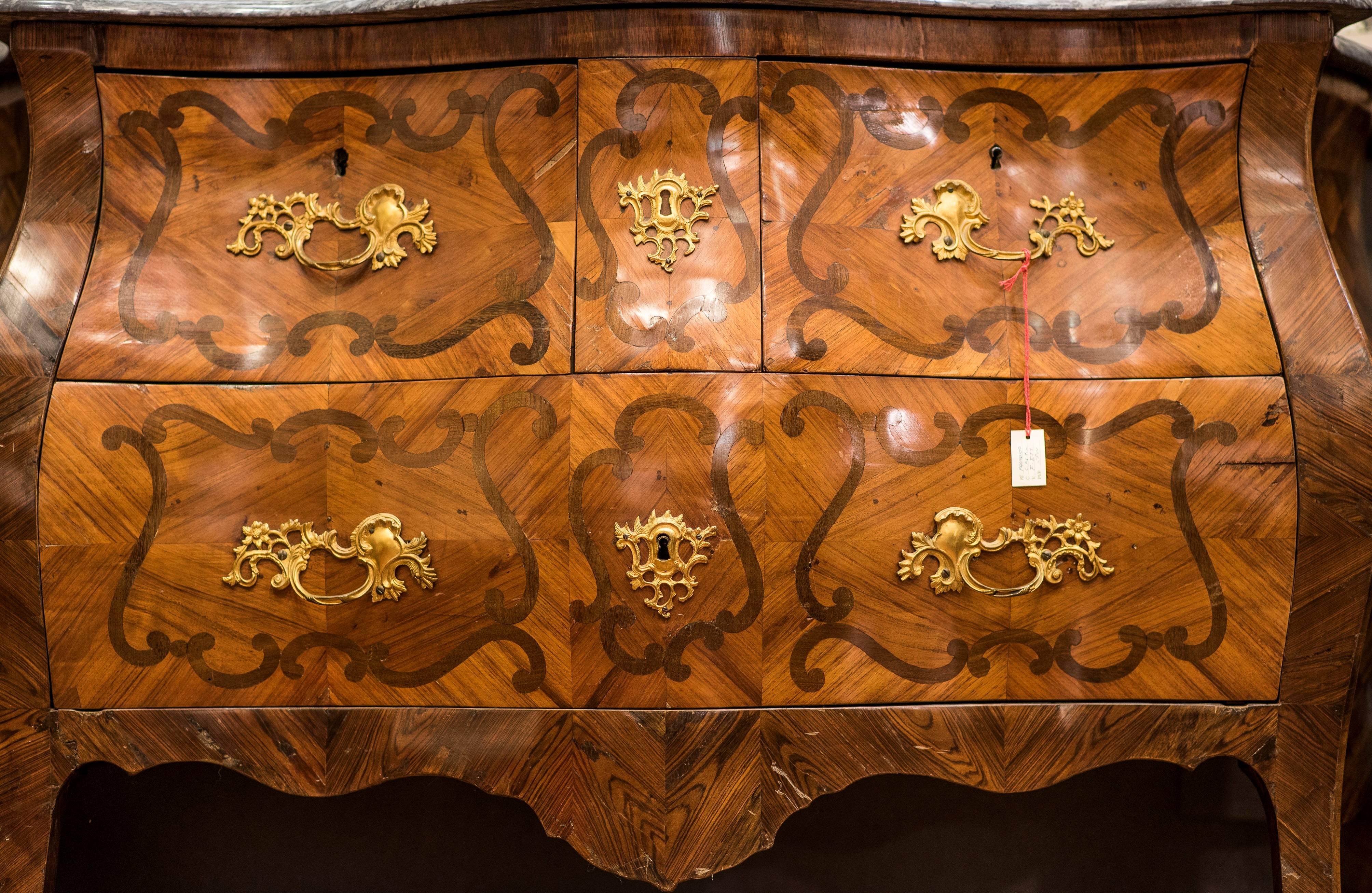 An 18th century French chest of drawers in mahogany, rosewood and walnut wood inlaid. With three chest of drawers and marble on the top. Shooters and keypads in golden bronze (ormolu).
 