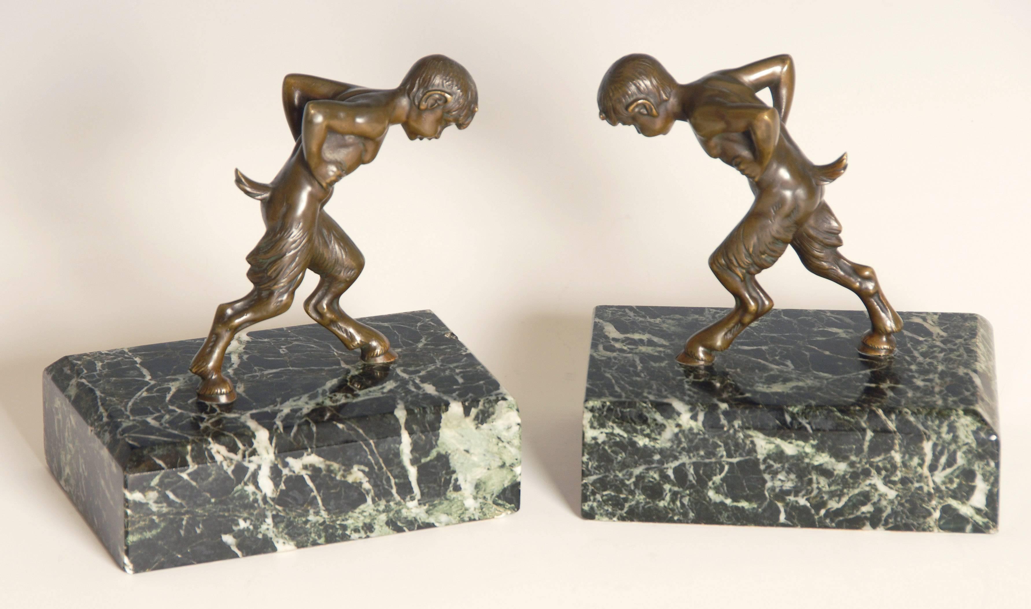 Pair of rare and unusual half boy, half goat / satyr / Art Deco bronze on heavy marble base bookends.

Measures: Each one is 5 inches wide x 3.5 inches deep and 5.5 inches high.
 