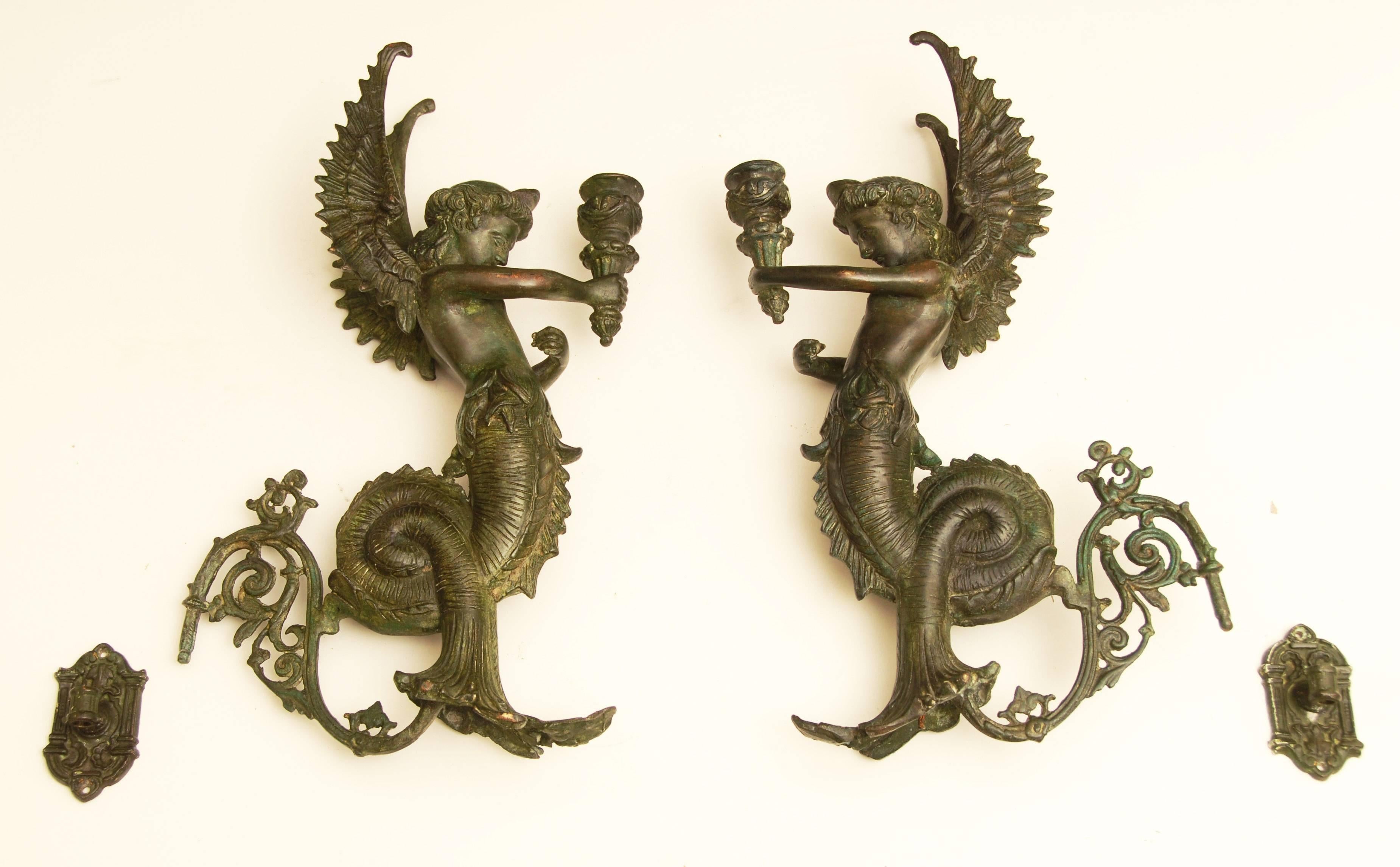 Magnificent pair of 16 inch high bronze Gothic Revival wall sconces/candelabras.
Depicting winged sea goddesses with serpent/fish tails holding torches.
Dating from circa 1900.
Requiring just two screws to each holding bracket, weighing 3 kg