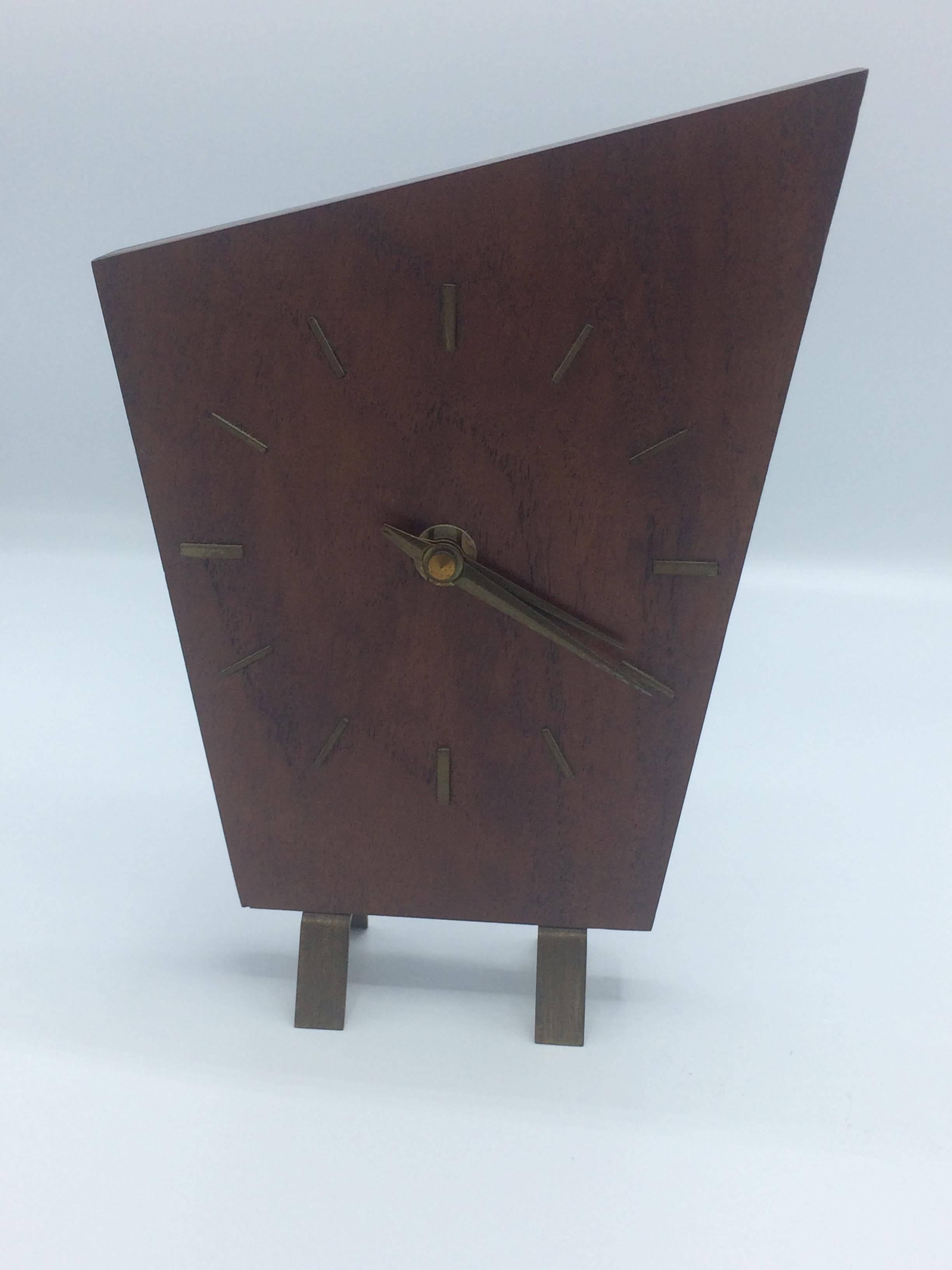 Gorgeous Minimalist table clock by Junghans in a warm dark wood. No Arabic numbers. Just the geometric form and the Mid-Century Modern feel. Wonderful piece. Full working condition, uses ready available batteries.