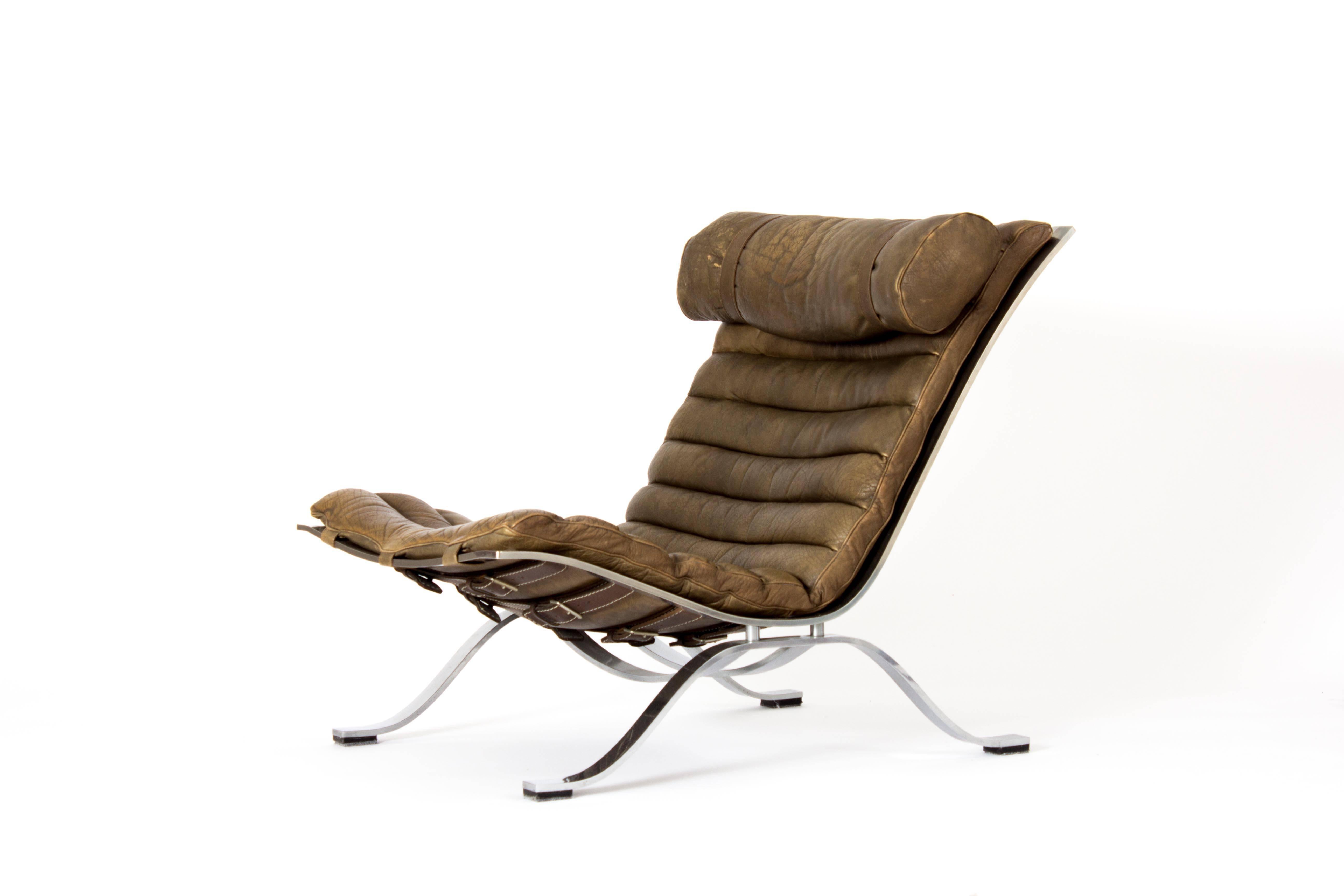 This Ari lounge chair was designed by Arne Norell for Norell Møbel in the 1960s. It has a chromed spring steel frame and seat and back cushions in channel-sewn leather that has aged beautifully, with a patina that is somewhere between brown and