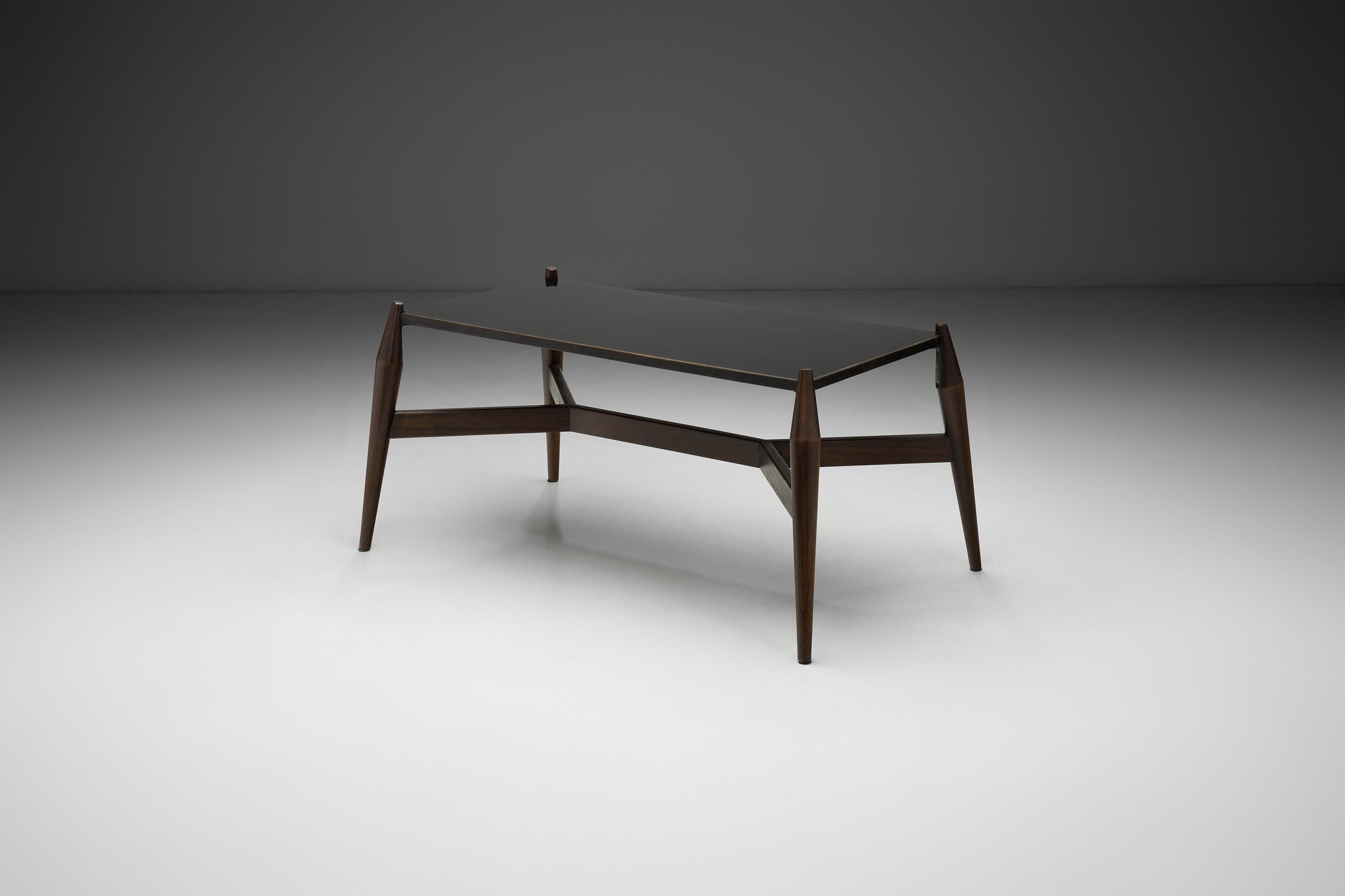 Avec sa structure distinctive, cette table incarne la recherche de nouveaux systèmes de menuiserie au milieu du siècle dernier, lorsque les matériaux et le design sont devenus les principaux facteurs de stabilité, de durabilité et, bien sûr,