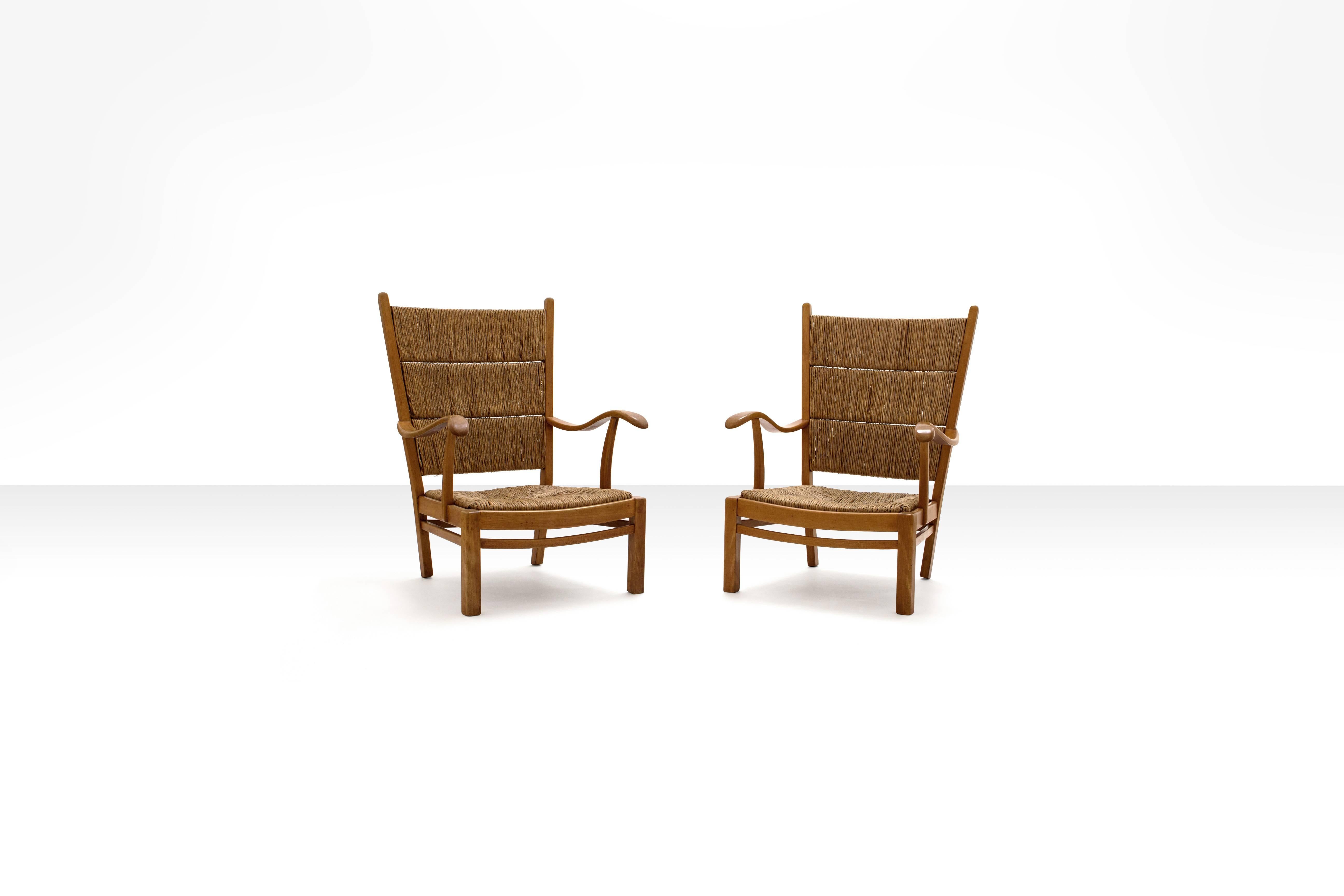 Elegant pair of armchairs in solid oak and straw, designed by Dutch designer Bas Van Pelt. The construction of this rare early 1940s, design is quite traditional and basic, yet very elegant and clear due to the open character of the frame.
