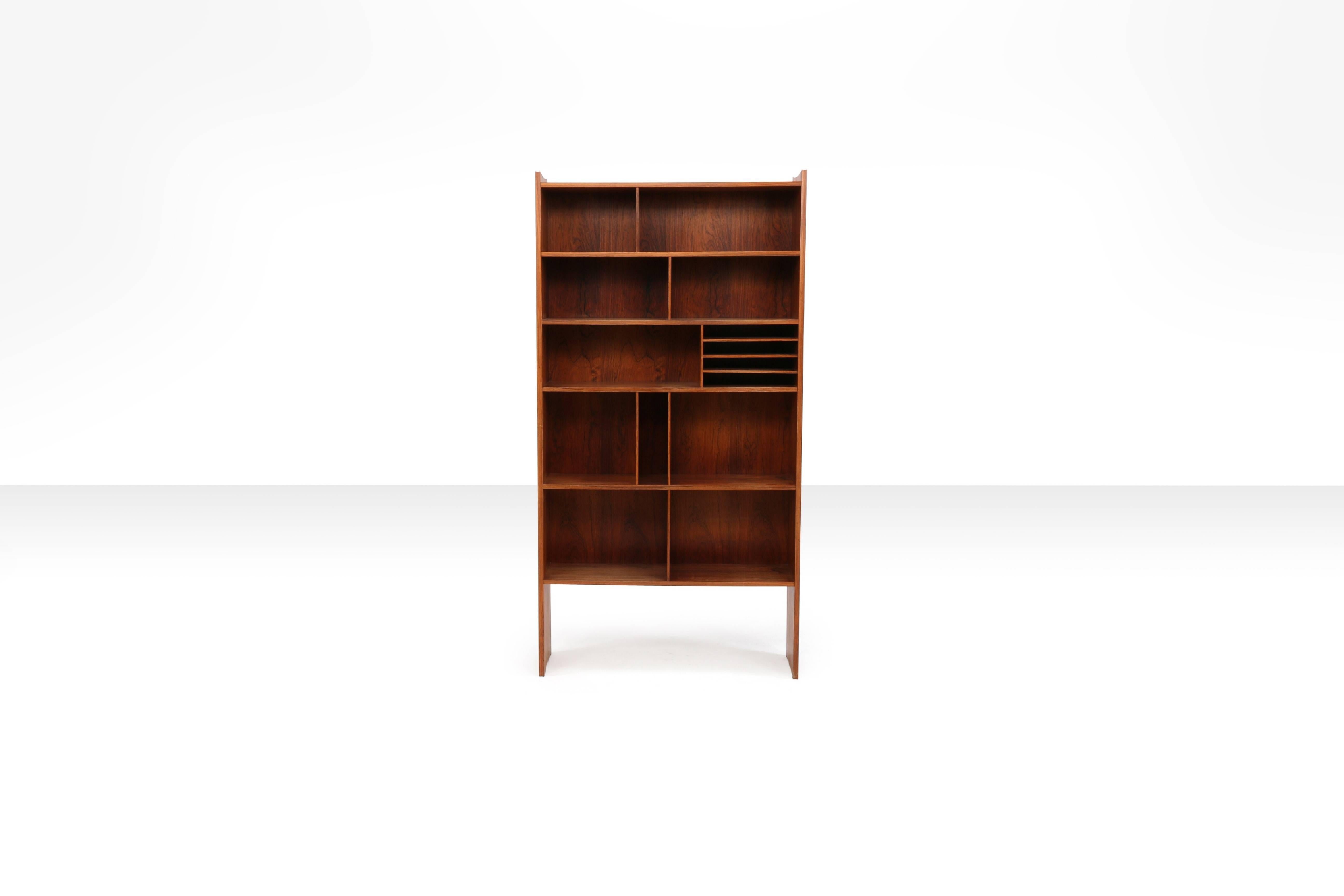 This rare bookcase was made early 1960s by cabinetmaker J.H. Johansens Eftf. v/ Henning Jensen and was presented at the Copenhagen Cabinetmakers' Guild Exhibition at the Designmuseum Denmark in 1961. 

Like a reviewer at the time wrote: 