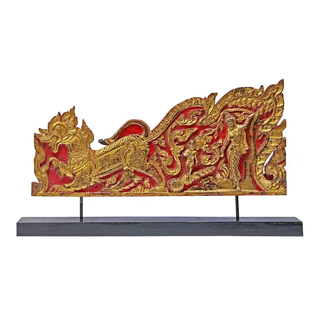 Two fine relief carvings, depicting the birth and death (Maha Pari Nirvana) of Buddha, originally forming the sides of a monk's throne, carved from teak wood, painted red with gilding and mounted on a custom stand made from reclaimed teak. The
