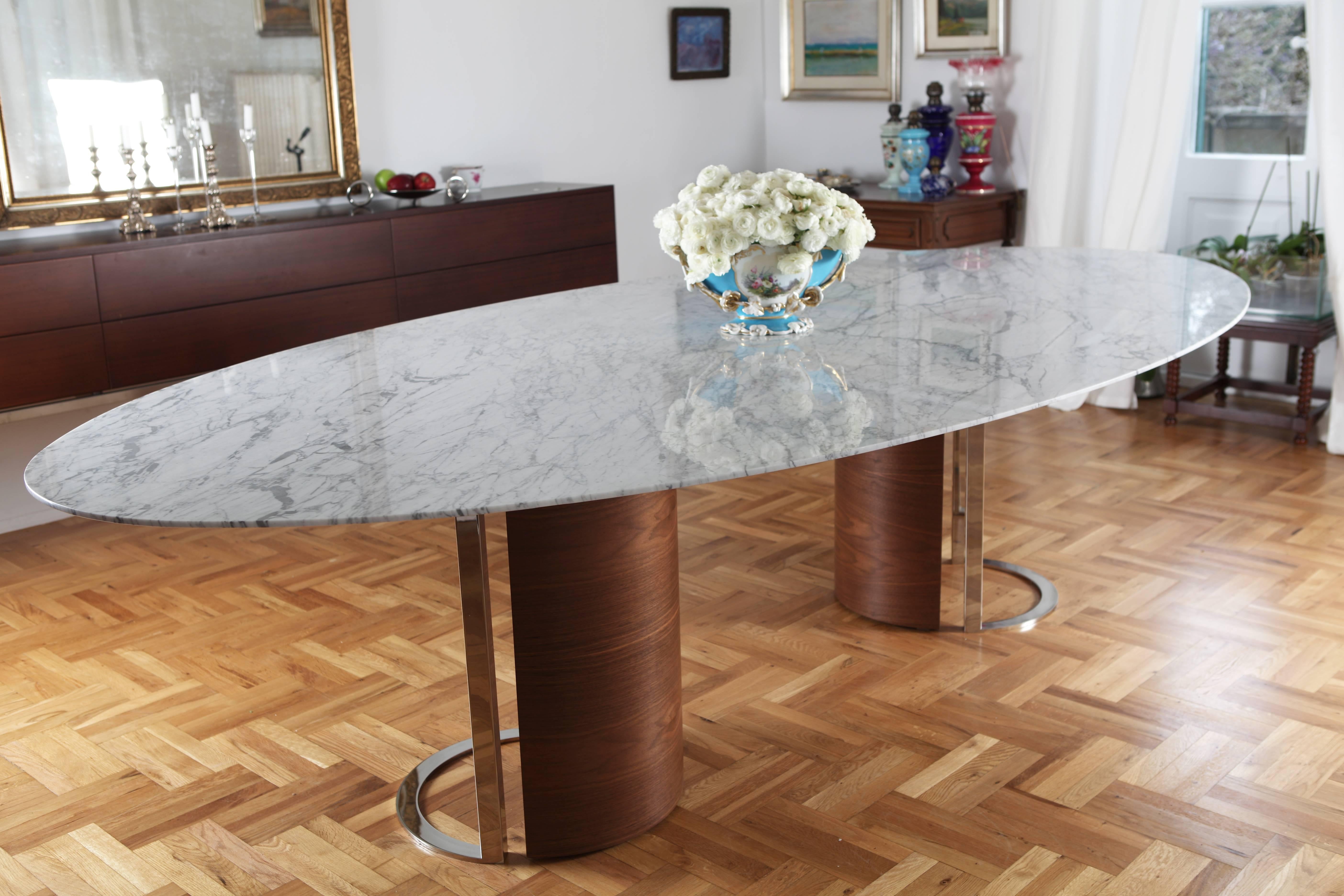 Contemporary Carrara marble 'Kayra' dining table with walnut veneer and stainless steel legs. The 1cm thick Carrara marble is from Turkey. We used the highest quality Carrara marble, cut to an oval, that seats up to 12 people. The table took its