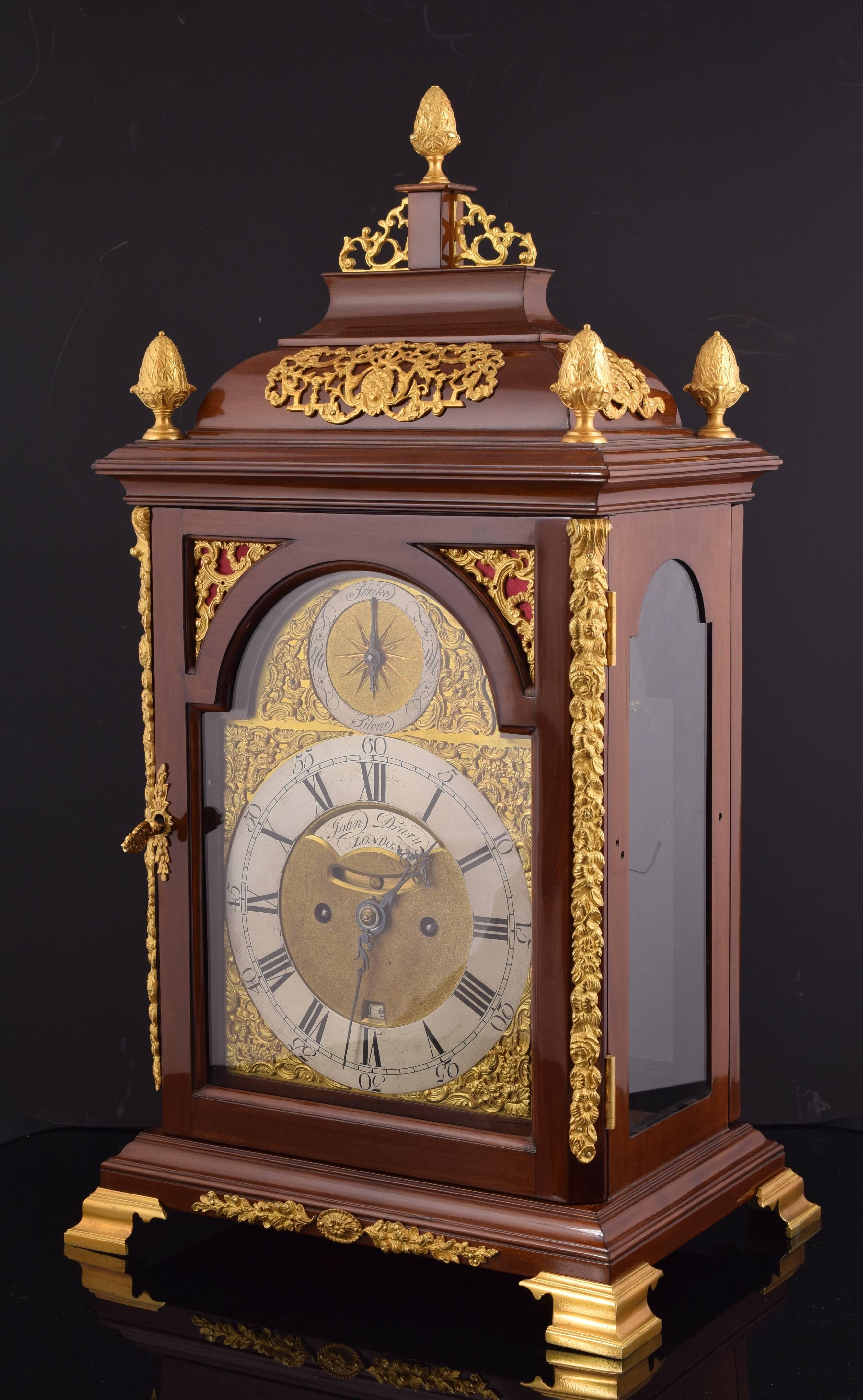 Seven bells chiming.
Working. Original machinery.
English bracket clock desktop type with wooden box fruit and ornamental bronze relief applications and round. It presents a front simple architectural composition, with a facade finished off in