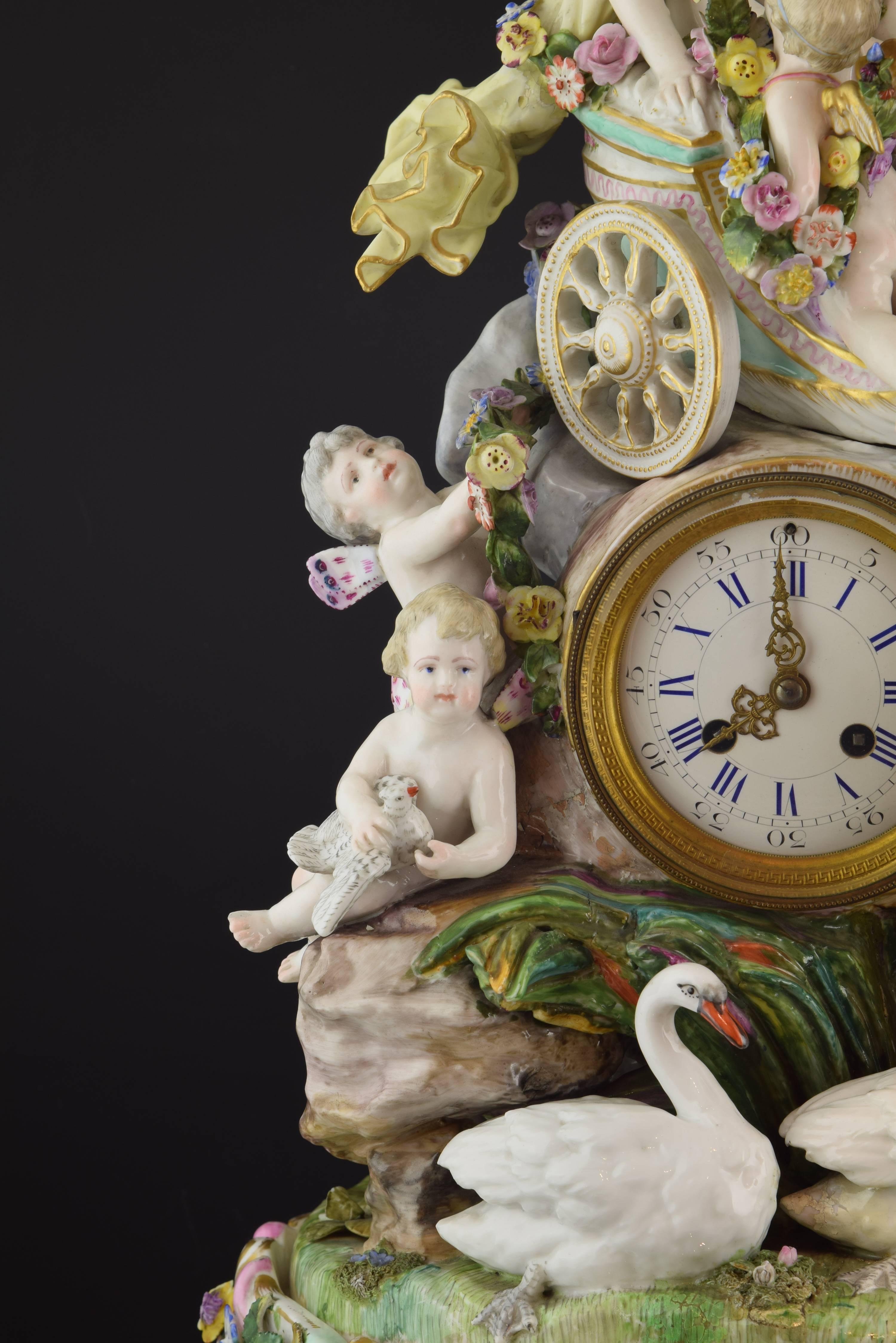 Glazed porcelain, metal, glass.
The base of the watch has lines with pronounced curves and outstanding movement, in the line of Rococo works of the 18th century, and has been enhanced with flowers of various colors and sizes. On it, stands a rock