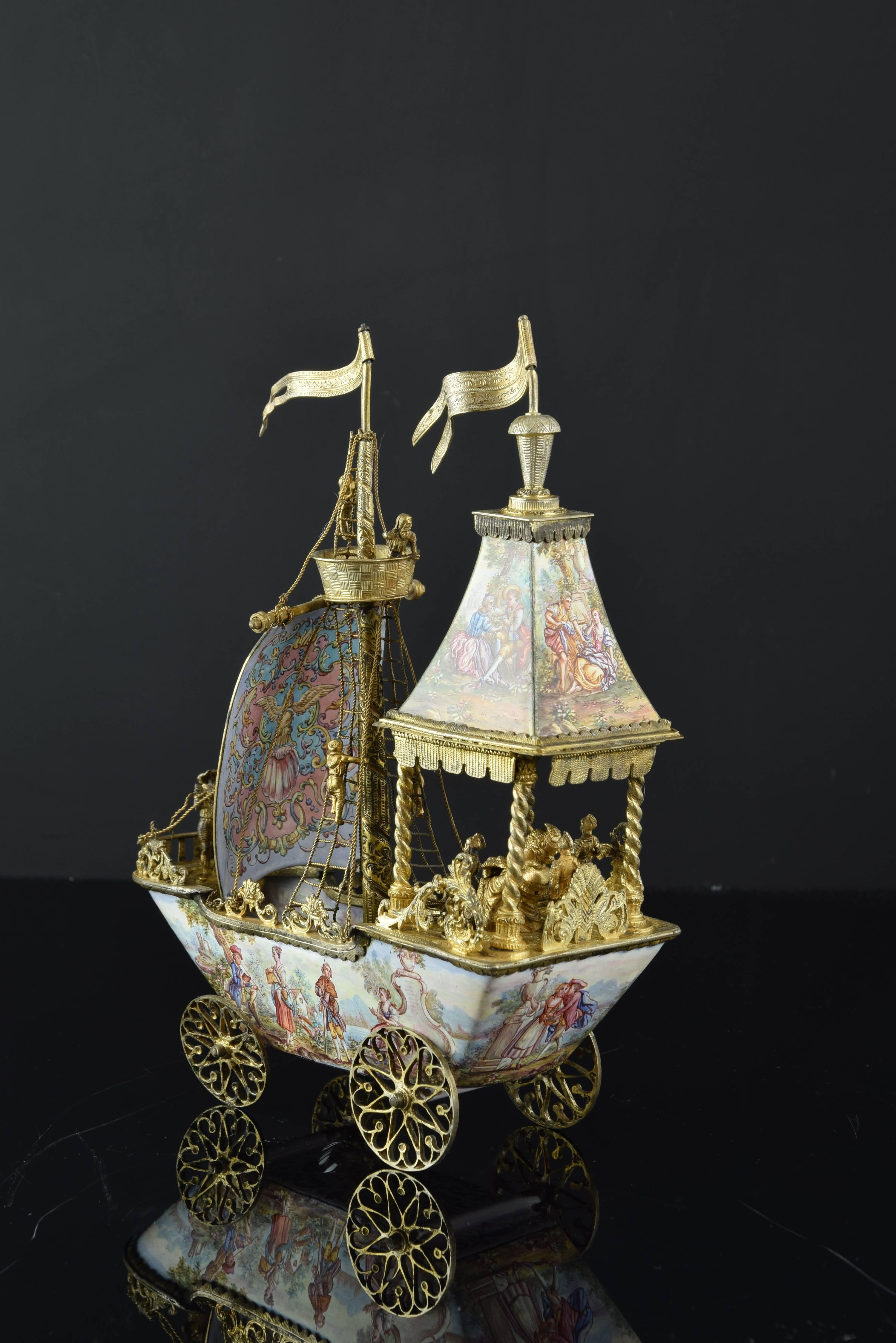 Viennese enameled centerpiece. Gilt silver and enamel. 19th century.
The four wheels that raise it present / display shafted axes, worked with simplified vegetal forms that interbreed. These, the railing of the deck, the rigging of rope, the mast,