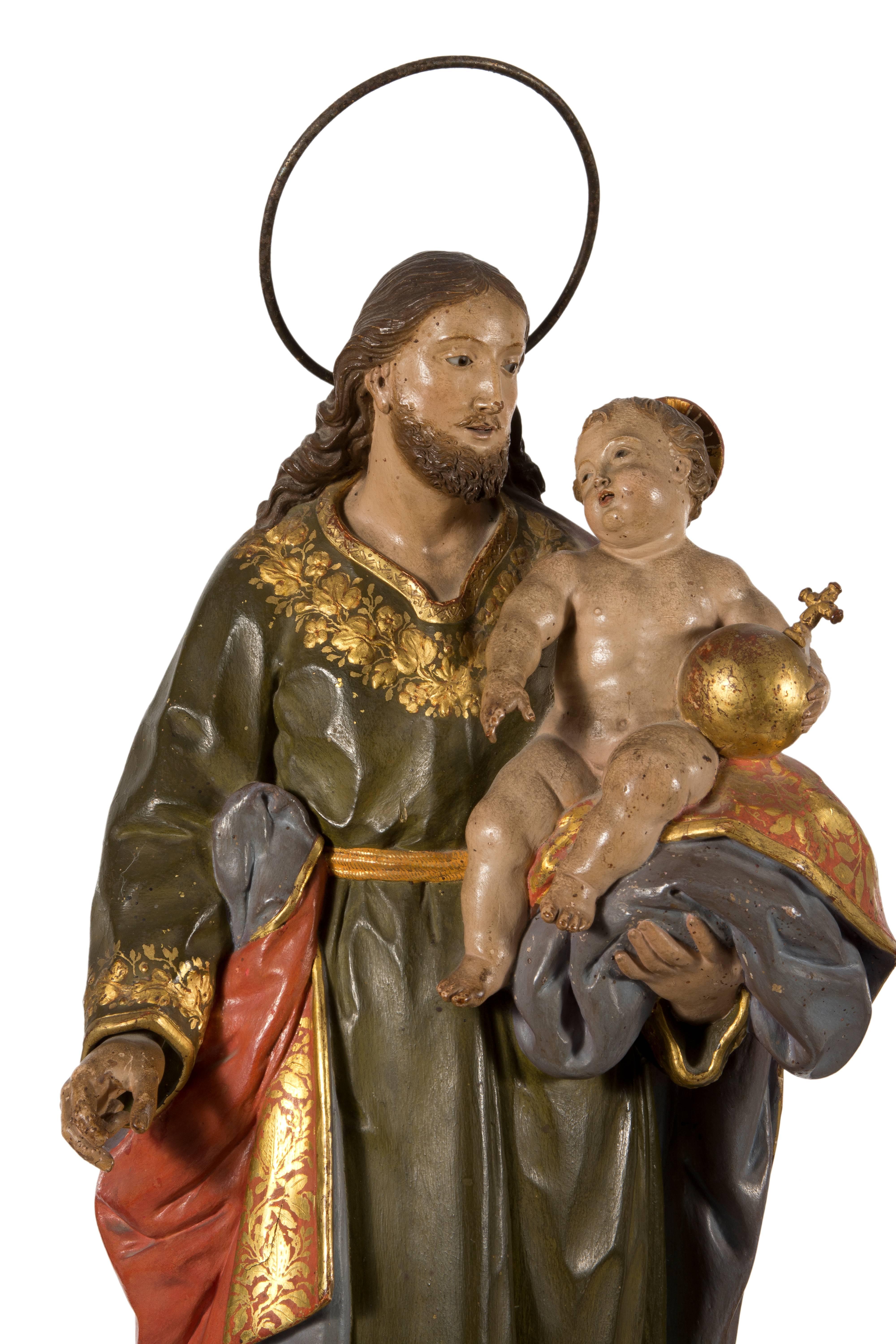 Saint Joseph with the child Jesus. Carved and polychromed wood. Andalusian school, Spain, 18th century.
The figure stands on a small pedestal with a rectangular base and a simple front, with clean lines, with two curves on the sides and a grill