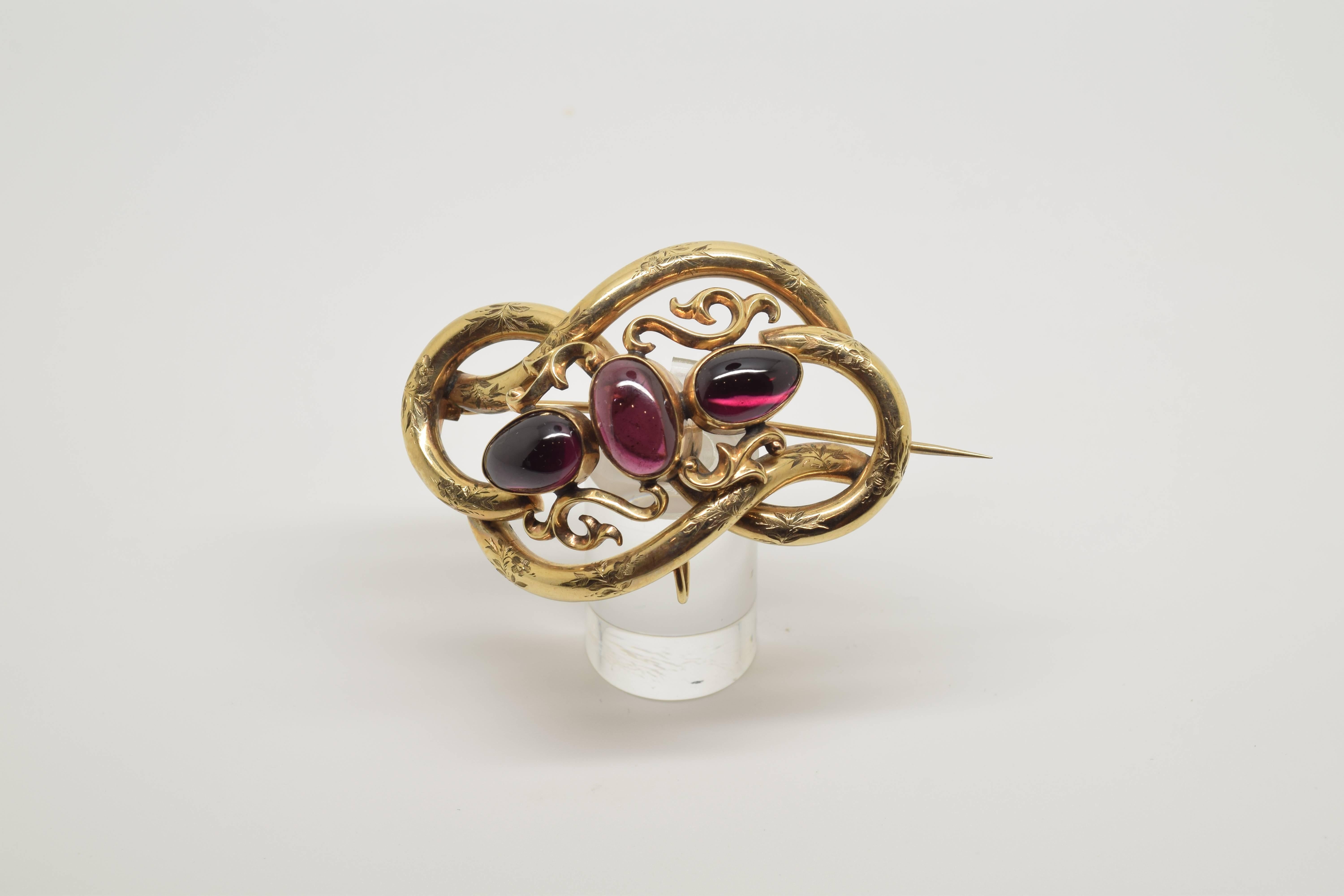 Lady's brooch made in 14-karat gold formed by a base shape arranged in a knot, leaving waves in the outer profile, with the surface decorated with fine vegetal forms of leaves and flowers. In the centre a few simple plant scrolls have been arranged,