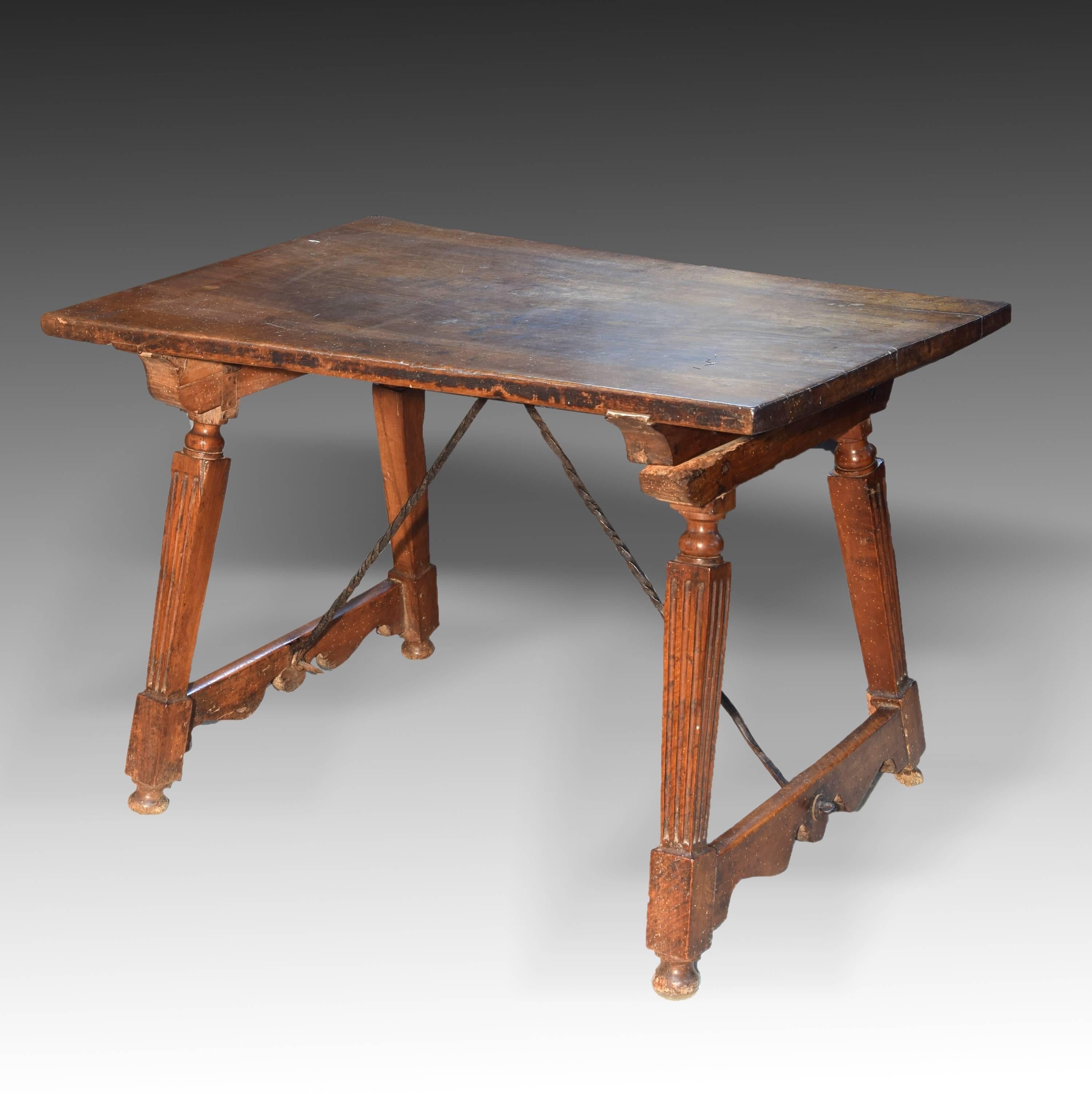 Rectangular board table ready on four legs in the shape of pillars with grooved shaft and square section placed on balls and joined in a dice, two to two, by lower chambranes cut in one of its profiles. The supports are secured to the table by means